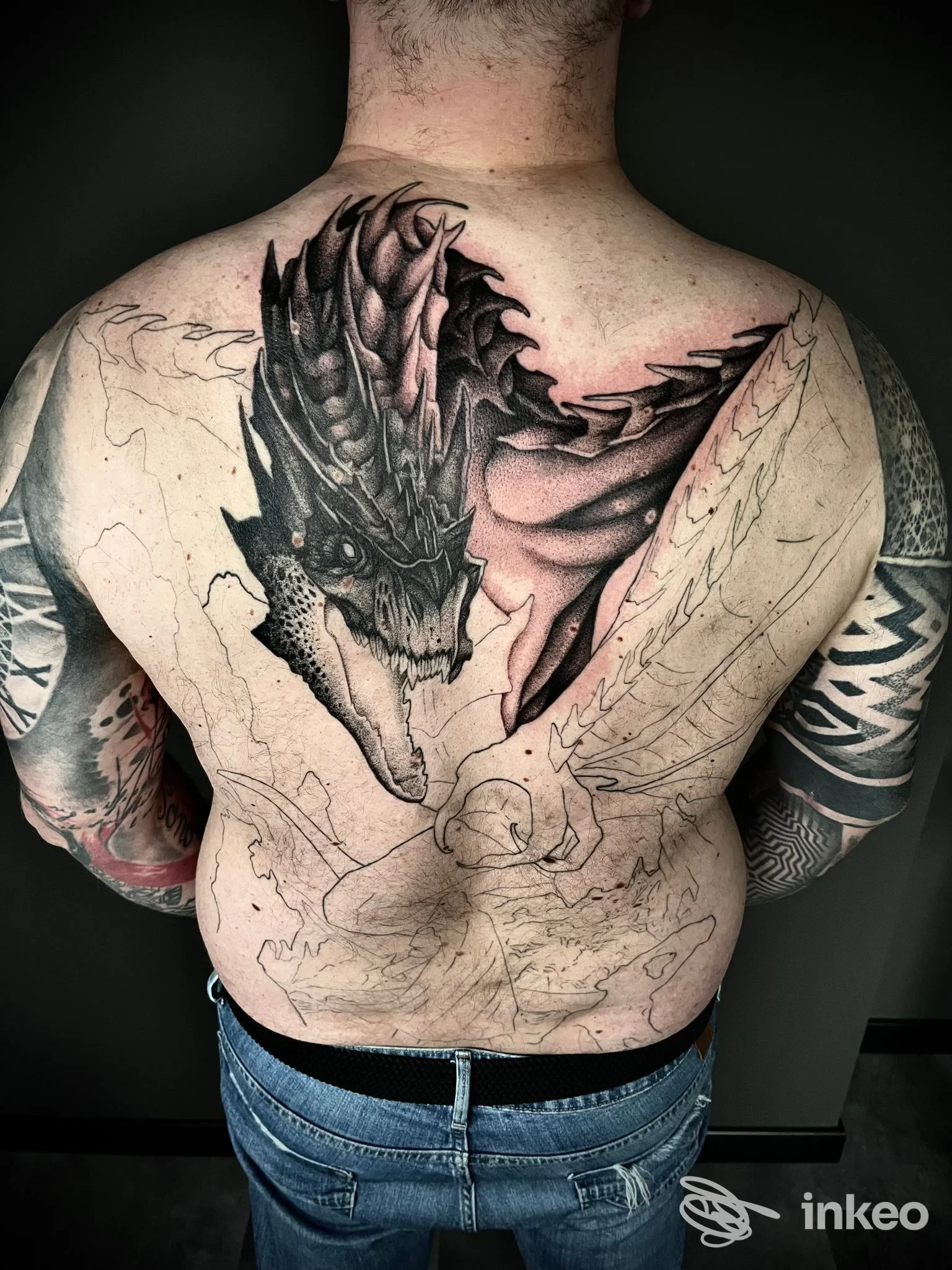 Grande tatuaggio a tema drago parzialmente completato sulla schiena di un uomo, foto per Artifex Tattoo Studio, Caldiero.