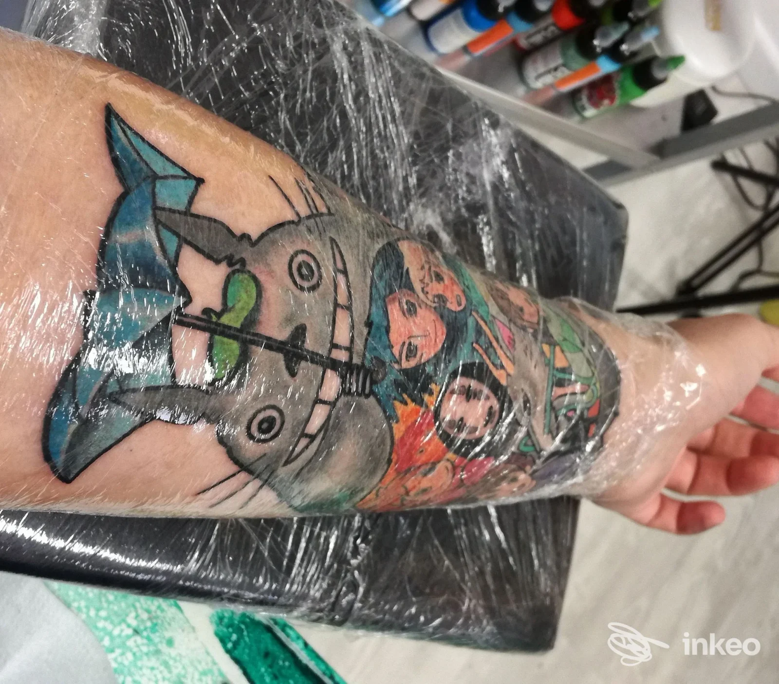 Avambraccio tatuato con più figure colorate avvolto in pellicola, foto fornita da BIKINI BOTTOM TATTOO STUDIO, Vicenza.