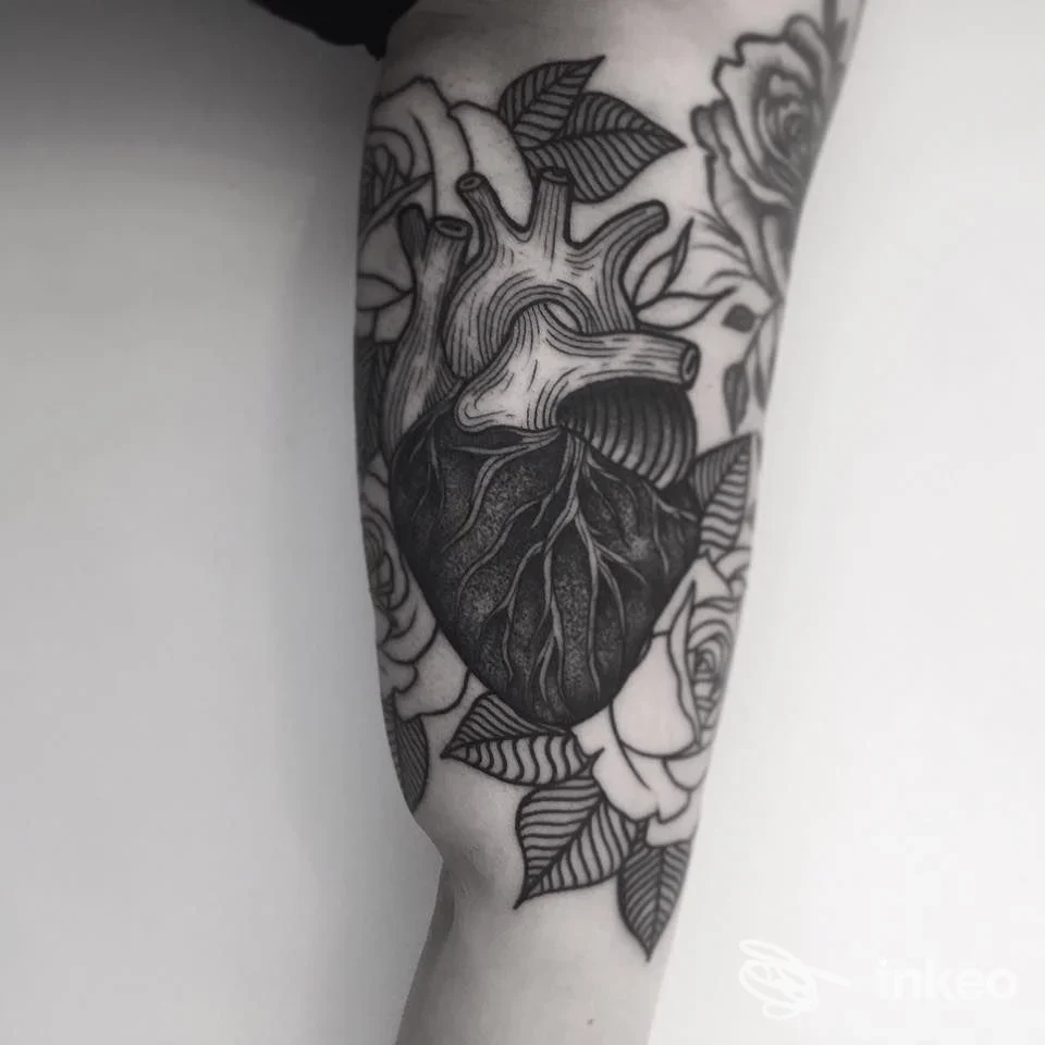 Tatuaggio a Venezia: cuore anatomico e rose in nero sull'avambraccio, lavoro fotografato in primo piano presso Alex De Pase Stores Tattoo e Piercing.