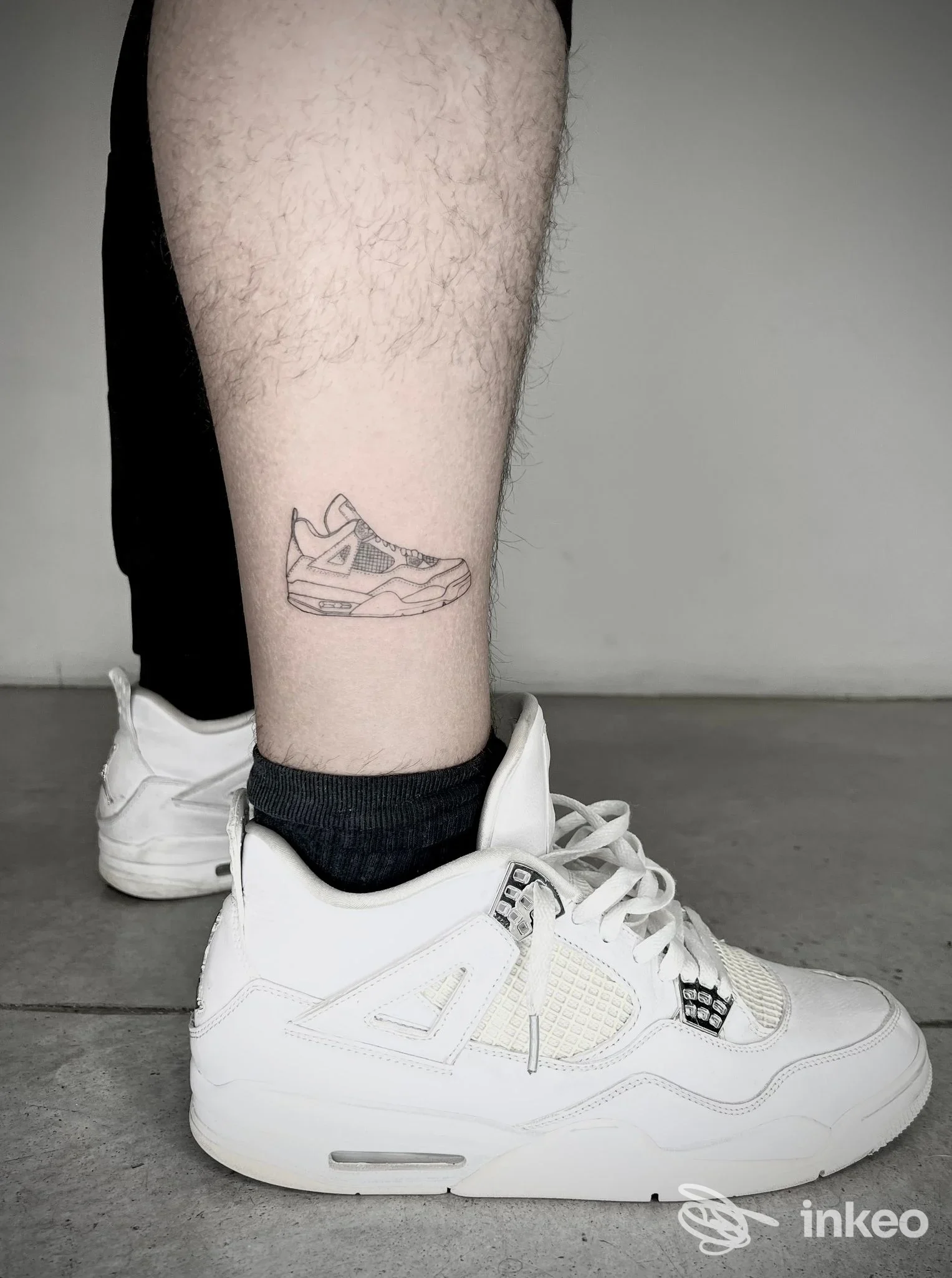 Piccolo tatuaggio di una sneaker sul polpaccio fotografato in studio; immagine fornita da Blaack ink tattoo studio, Vicenza.