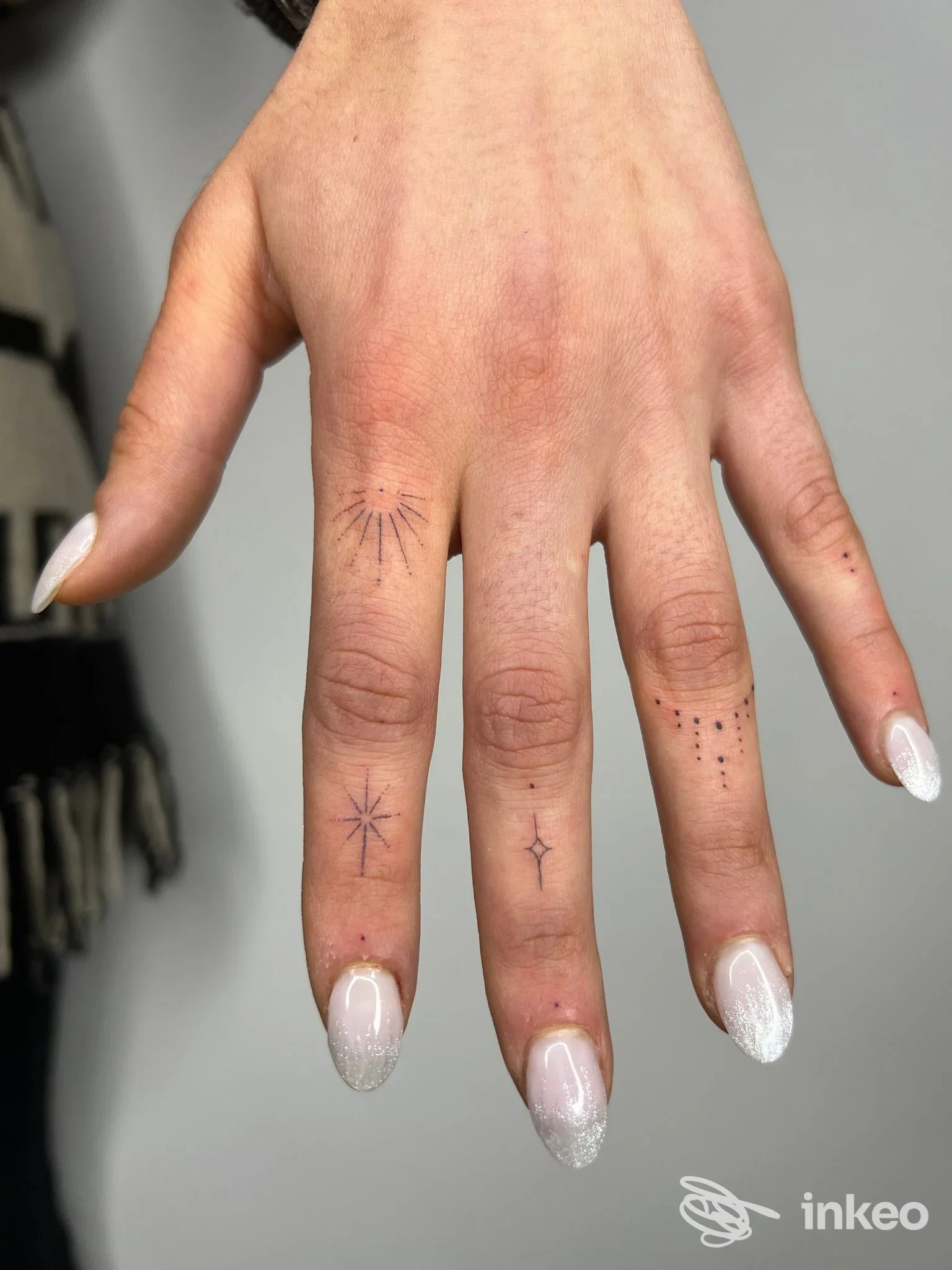 Primo piano di mano con piccoli tatuaggi minimalisti sulle dita, foto fornita da Blaack ink tattoo studio, Vicenza.