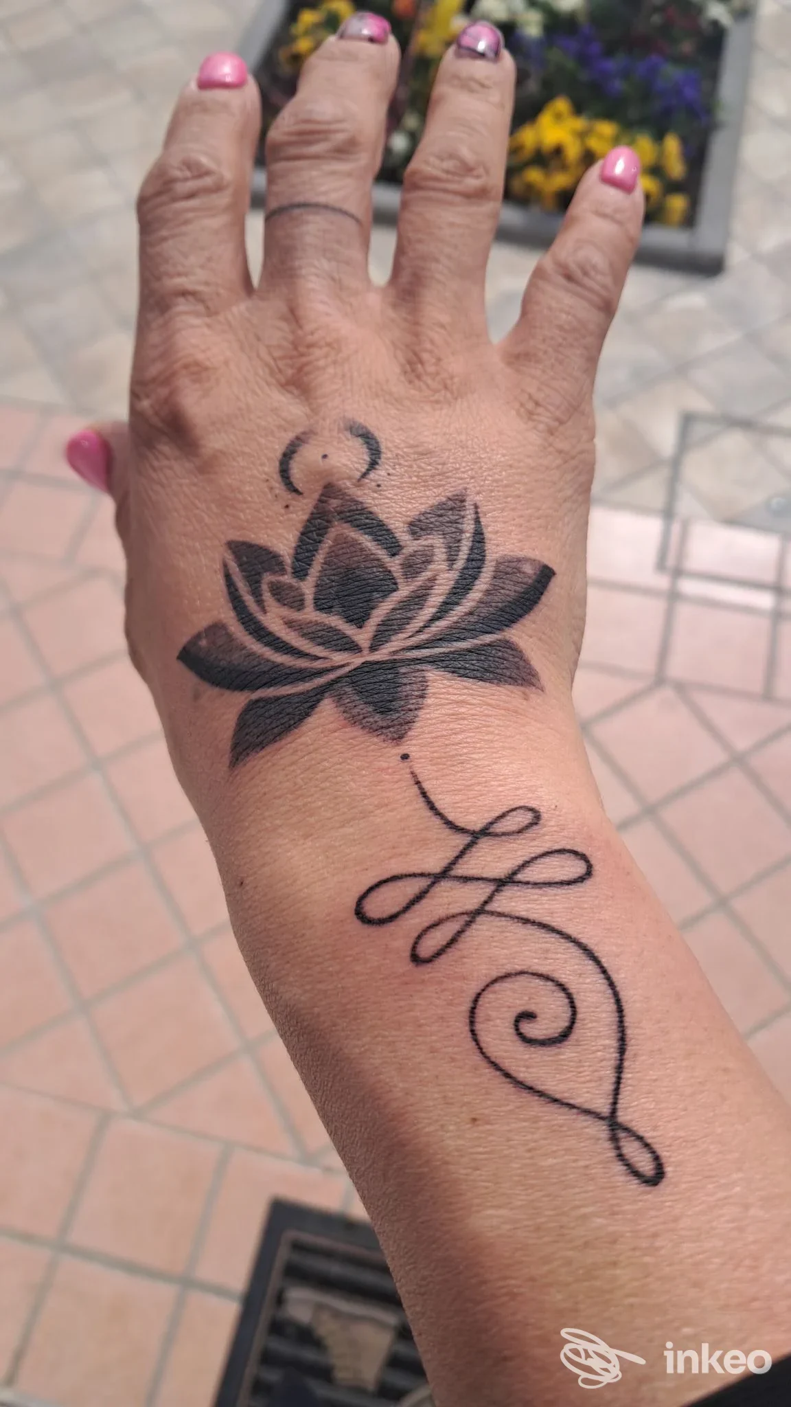Tatuaggio blackwork con loto e fregio sul dorso della mano, Black Ground Tattoo a Cologna Veneta.