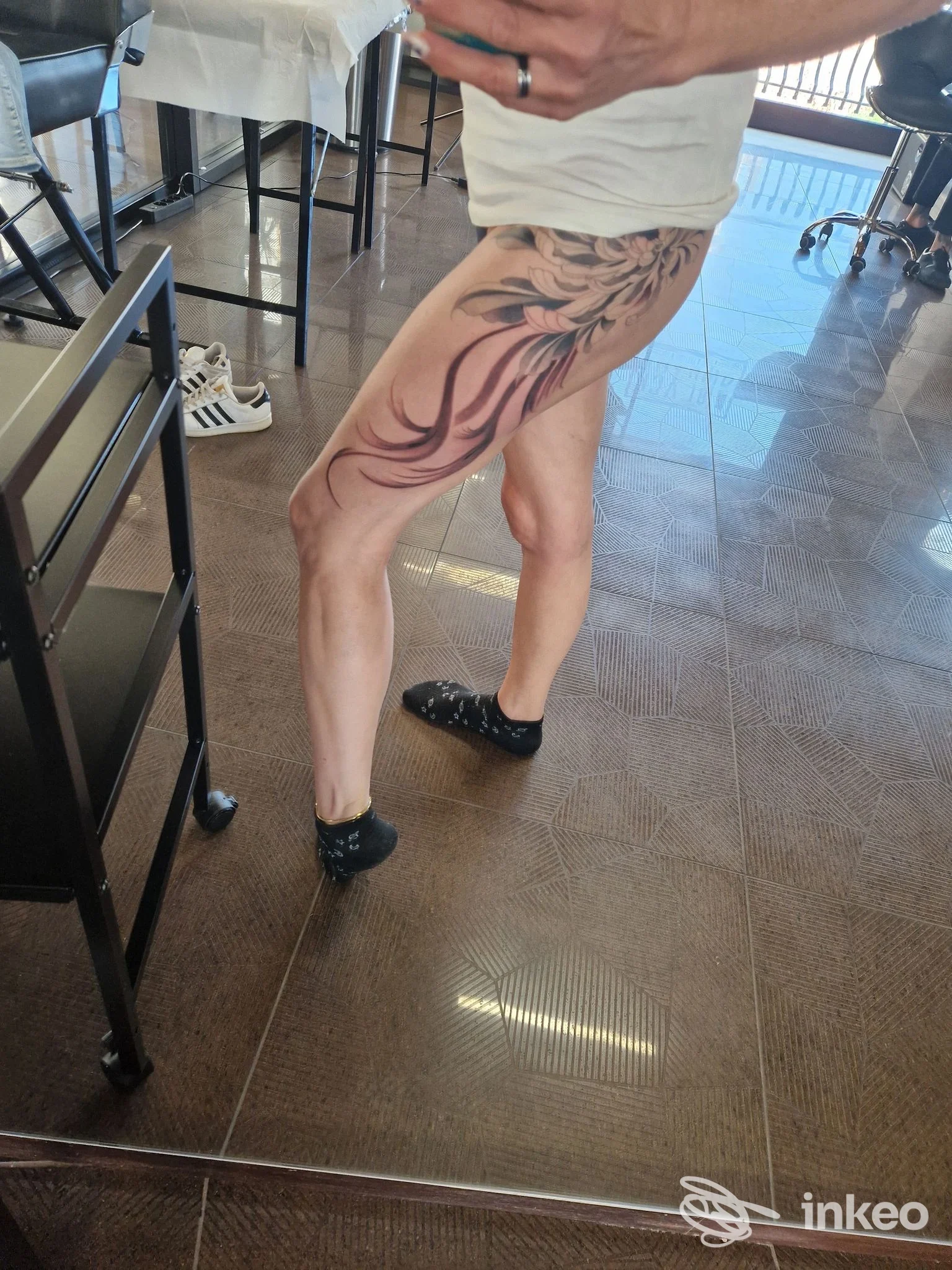 Tatuaggio colorato su coscia e fianco di una cliente, fotografia scattata nello studio Black Ground Tattoo a Cologna Veneta.