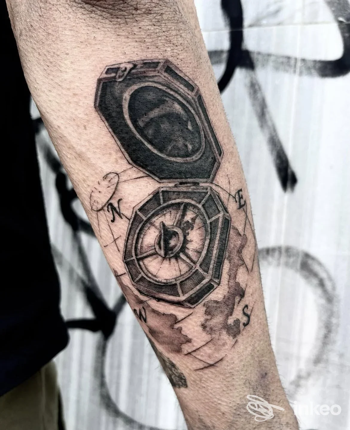 Tatuaggio black & grey a forma di medaglione/bussola sull'avambraccio, scatto dal Blk Rooster Tattoo & Piercing a Venezia.