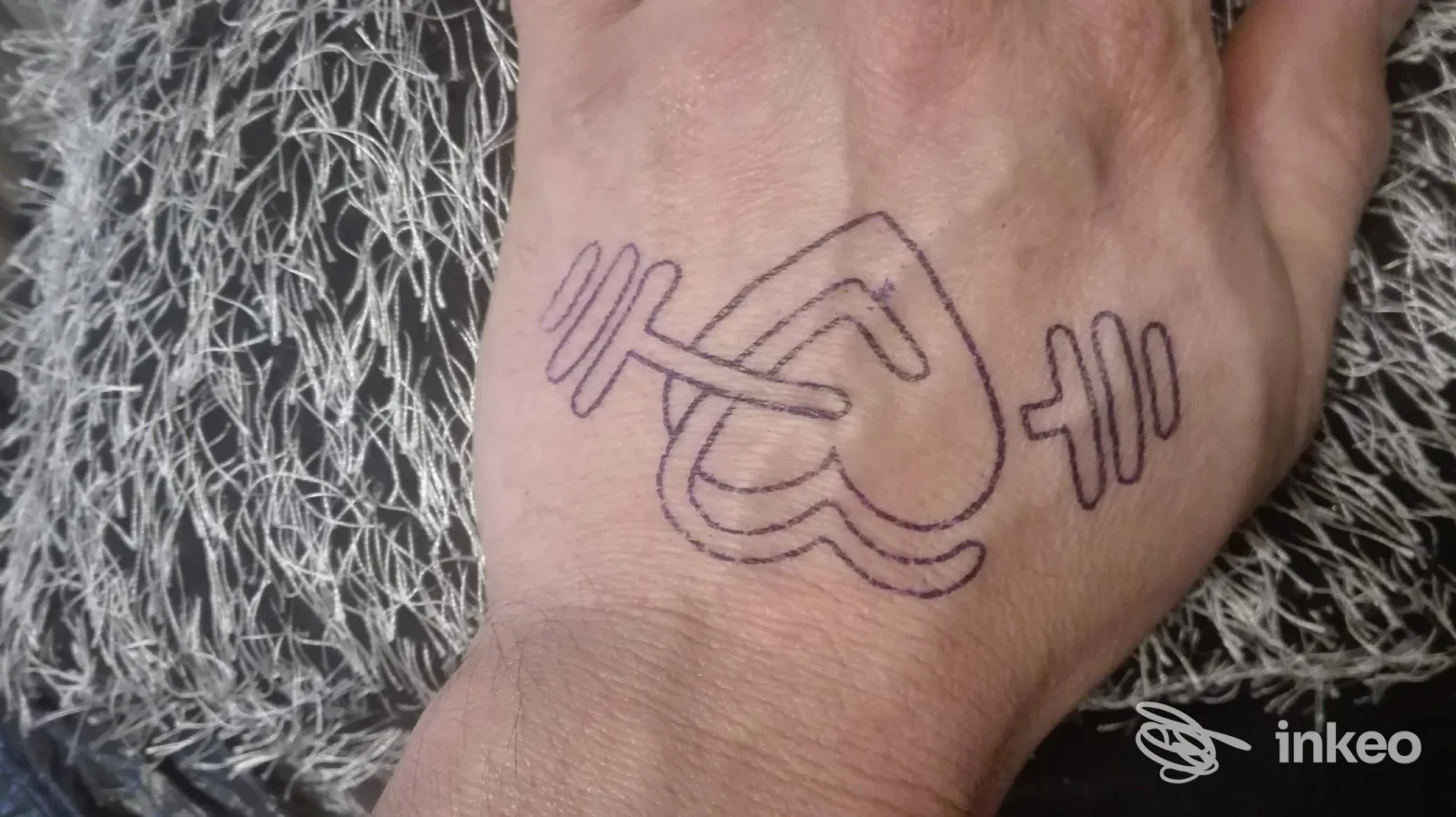 Tattoo raffigurante una stretta di mano stilizzata tra due pesi, realizzata sulla pelle della mano, visibile a Busnago presso Monikina Tattoo, tatuaggio sul dorso della mano.