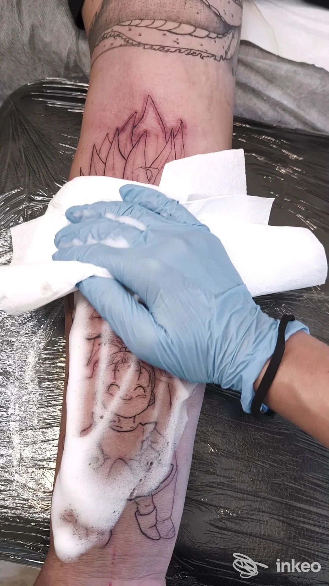 Tatuaggio in lavorazione sull'avambraccio, artista che pulisce la zona; Caterina tattoo, Codiverno.