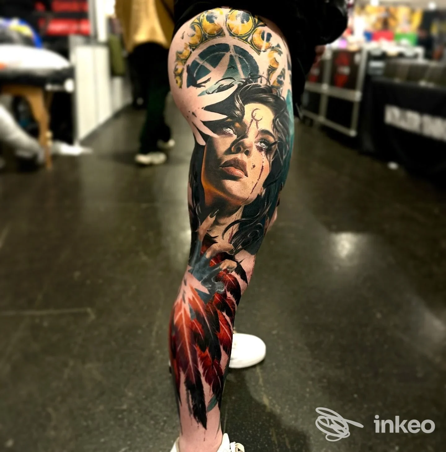 Tatuaggio a colori su gamba con volto e piume, foto inviata da Claudia Reato Private Tattoo Studio, Vicenza.