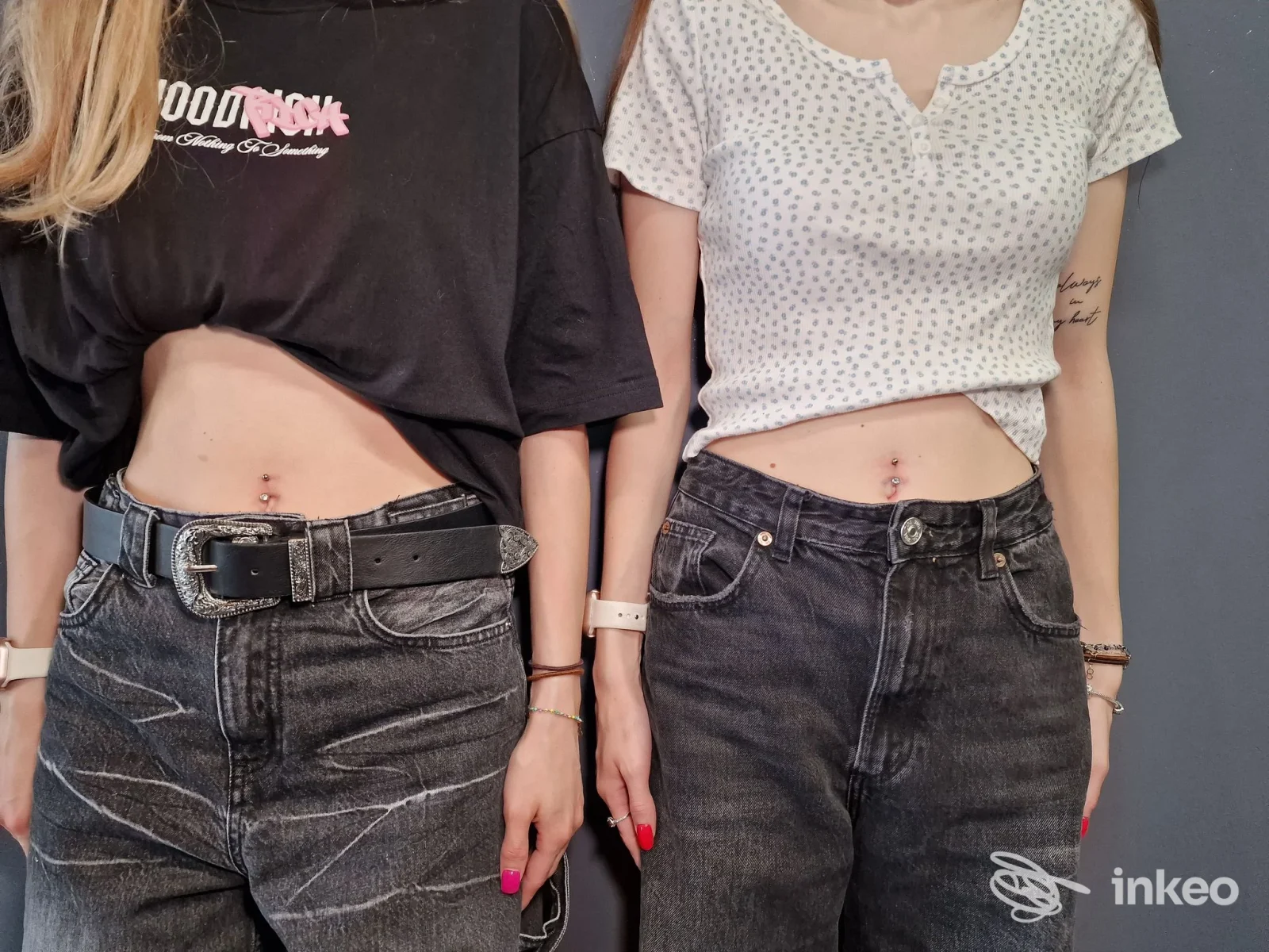 Due persone con piercing all'ombelico in foto studio DEMON - Piercing & Tattoo, Verona.