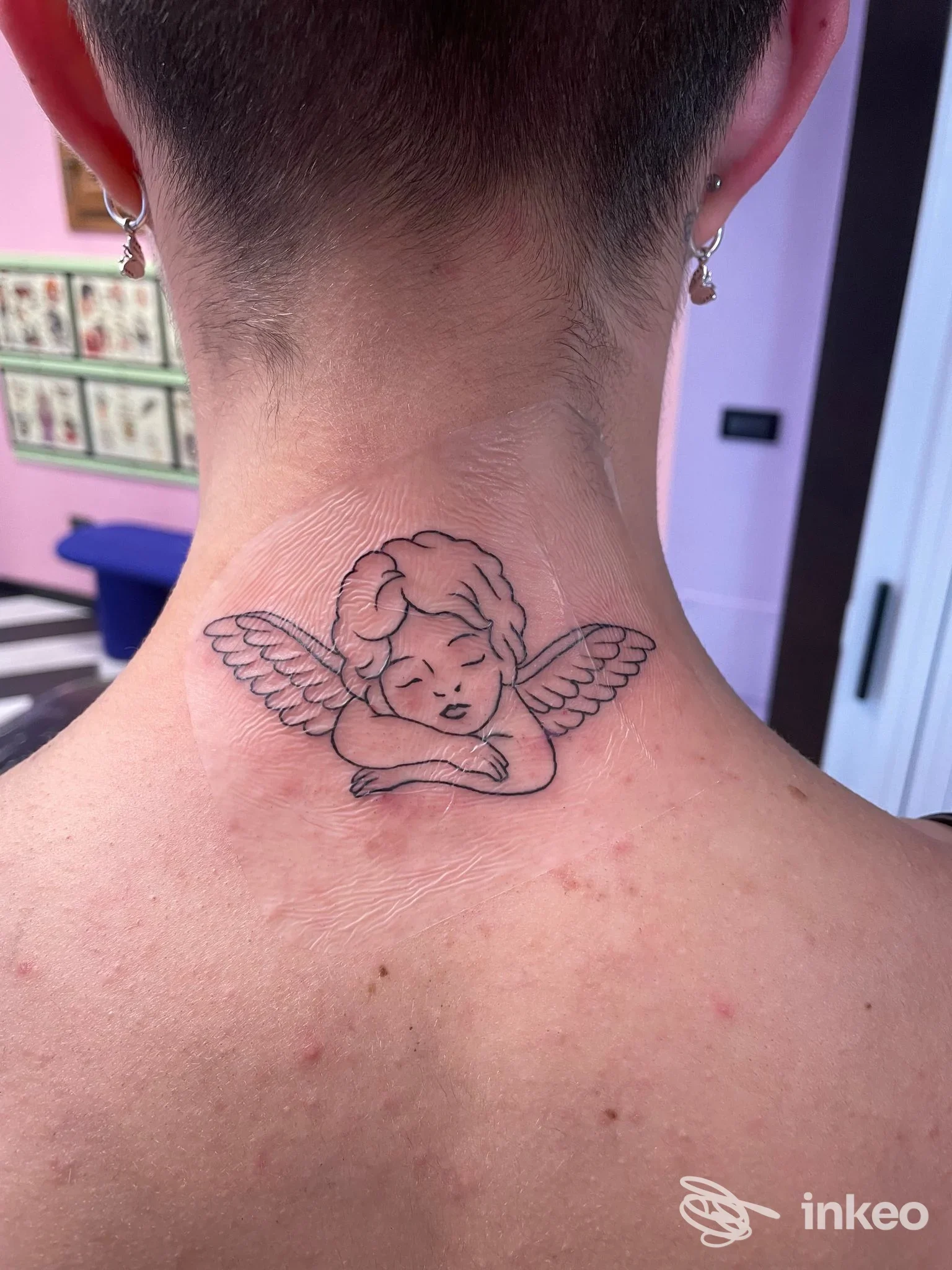 Tatuaggio a linee di un angioletto sulla nuca, realizzato da Death Club Tattoo a Bassano del Grappa.