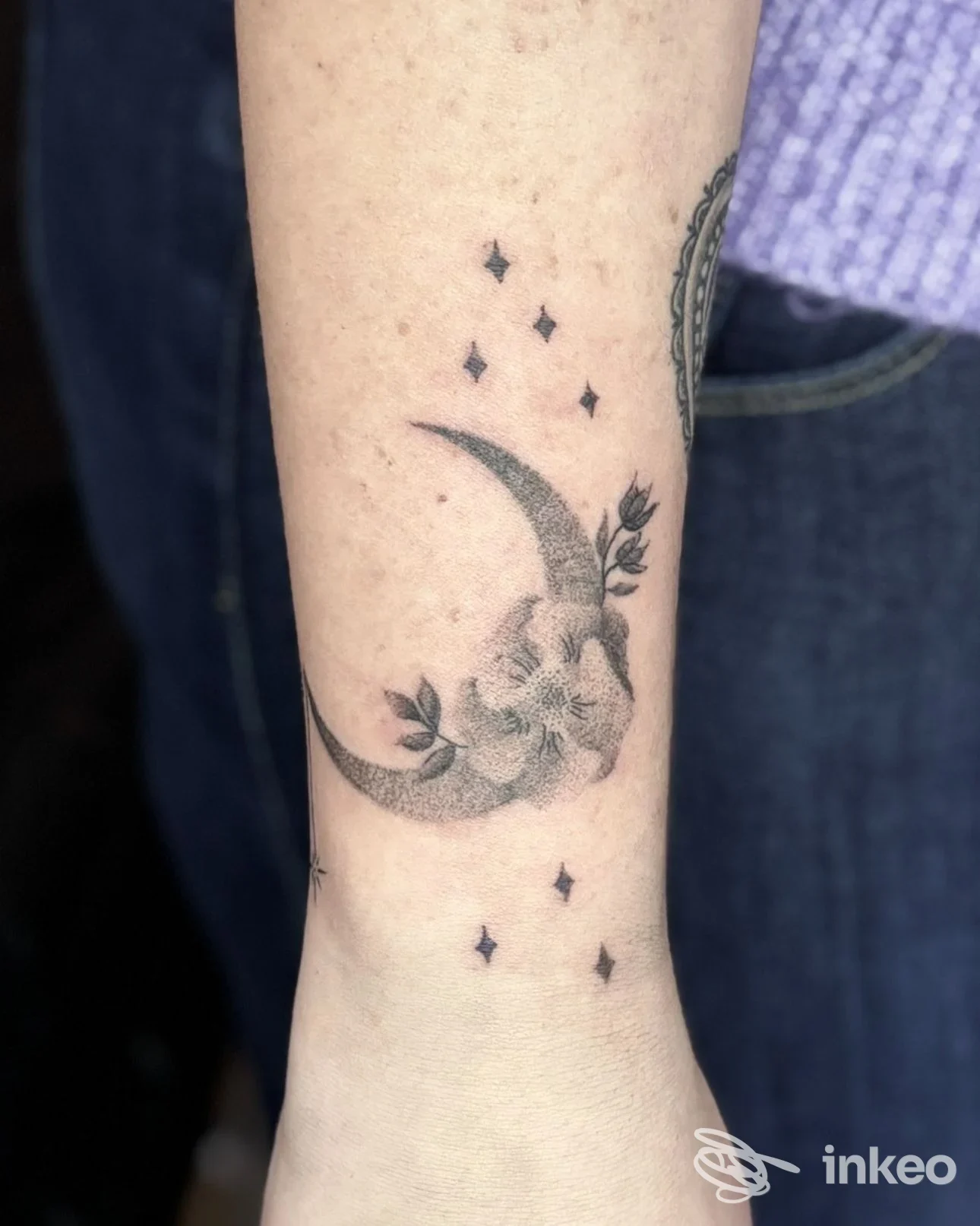 Primo piano di un tatuaggio a mezzaluna con fiori sull'avambraccio, foto fornita da Davide tattoo a Camposampiero.
