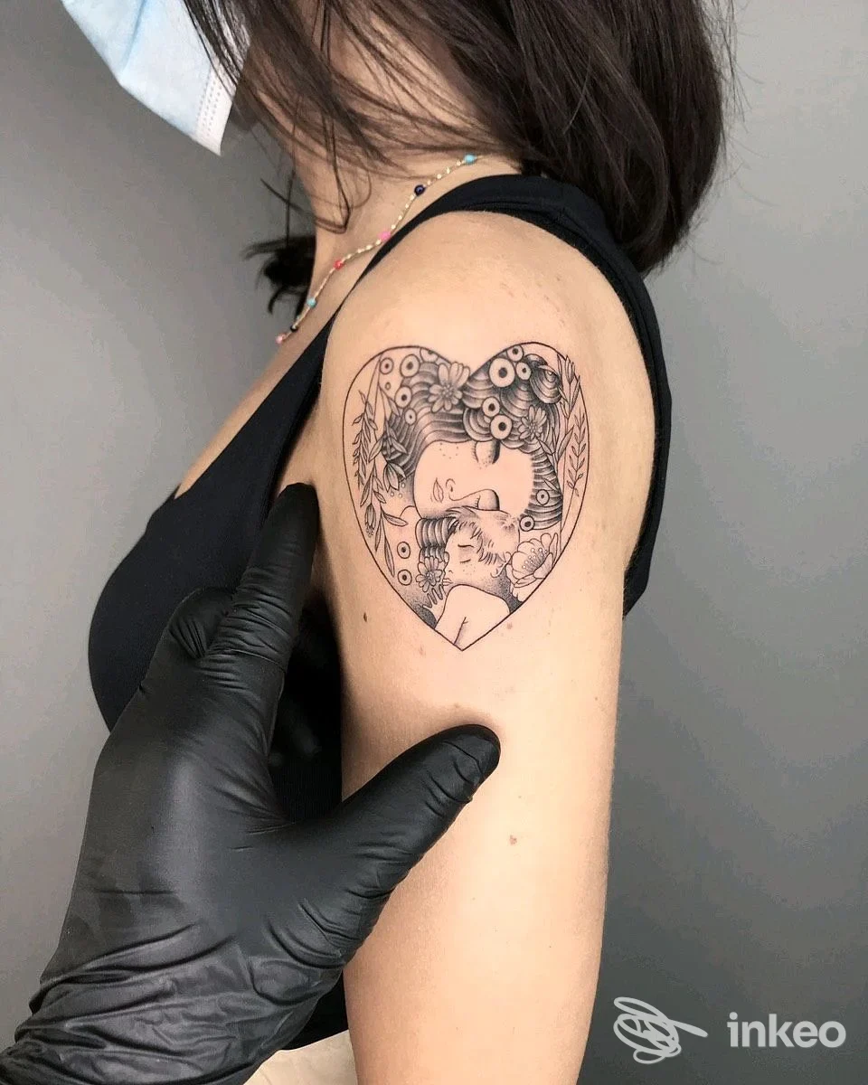 Tatuaggio nero a forma di cuore con figure sul braccio superiore, fotografato presso Deep Black Tattoo Studio, Strà-Montanara-Pieve.