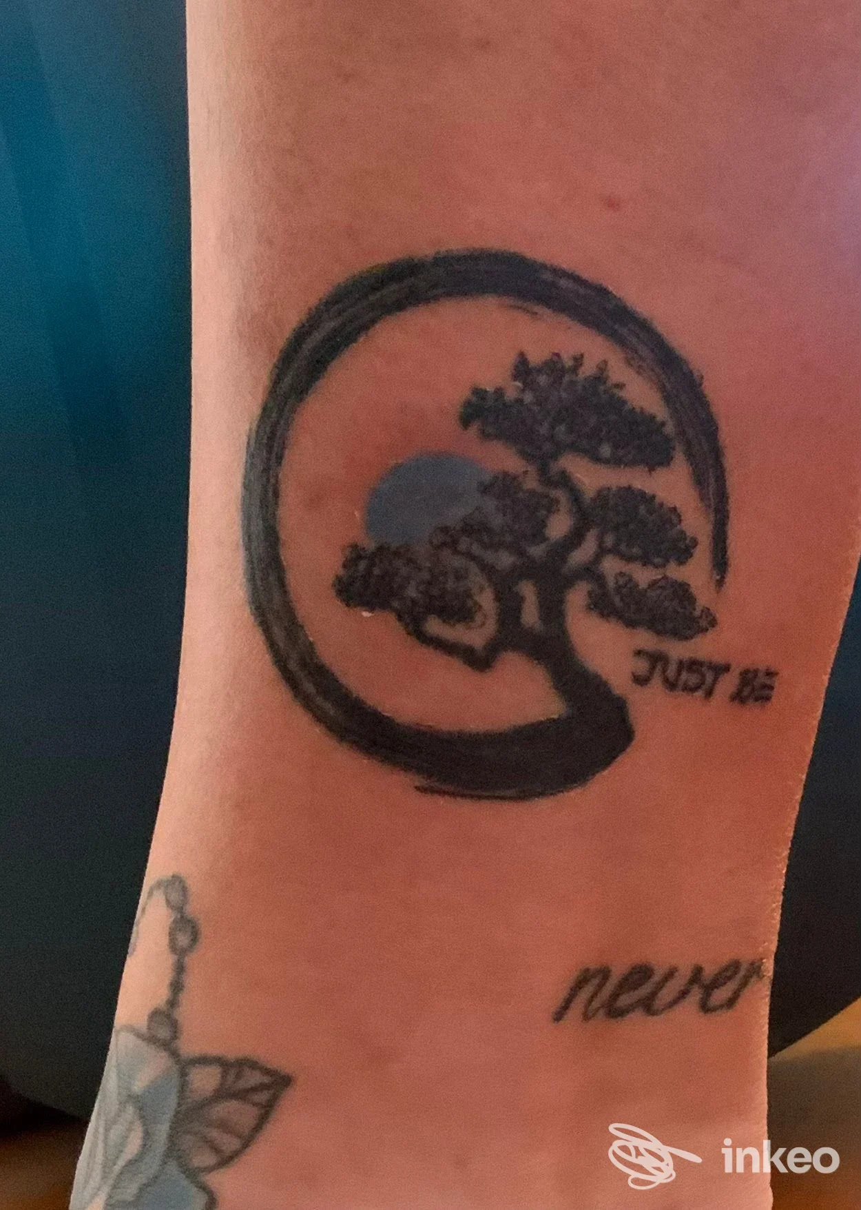 Tatuaggi in bianco e nero sull'avambraccio con albero circolare e scritta, foto fornita da FiArt tattoo, Malo.