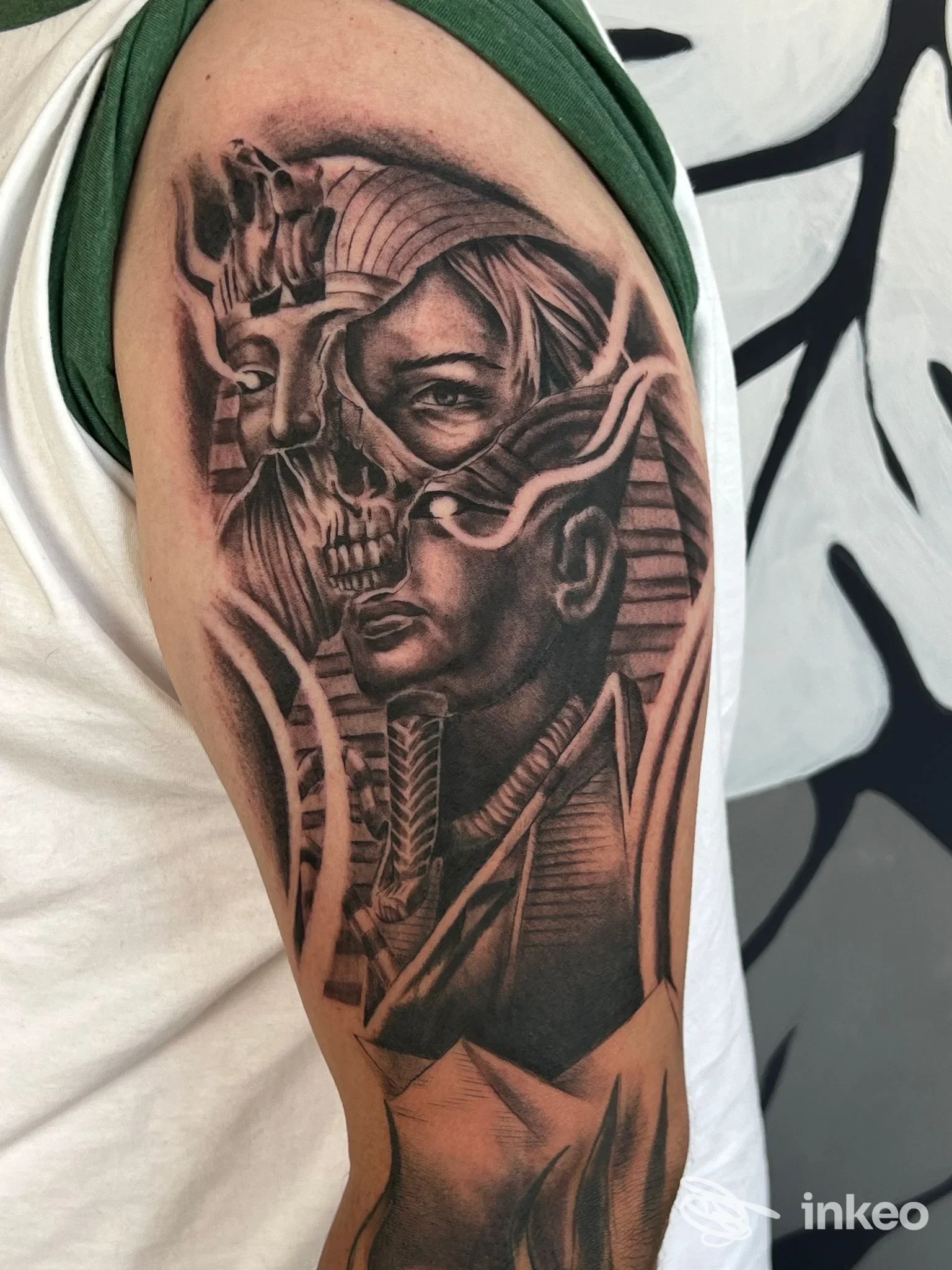 Tatuaggio in bianco e nero sul braccio superiore con volti e elementi egizi, foto condivisa da Double Tattoo Studio a Padova.