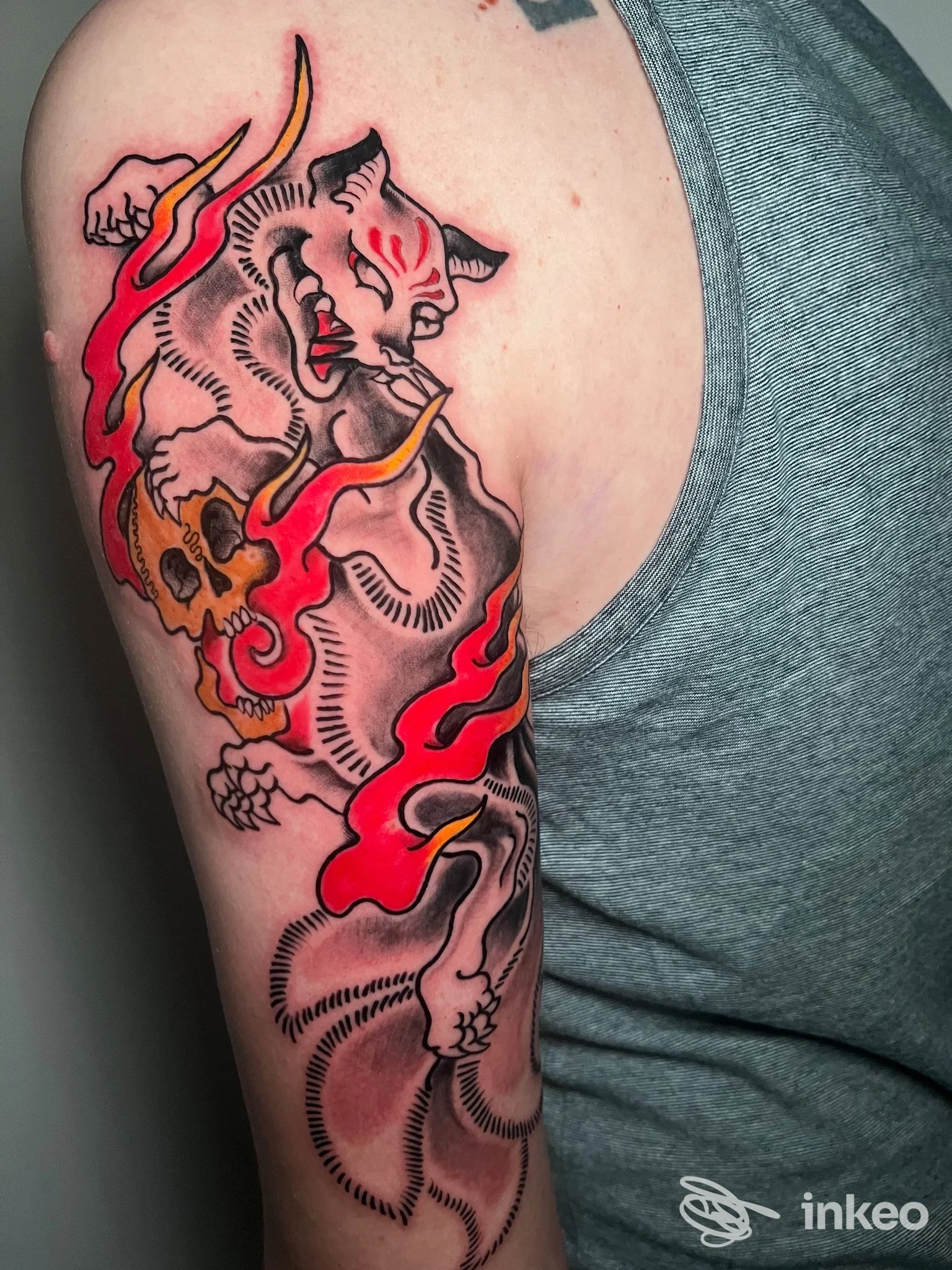 Mezza manica sul braccio superiore con grande tatuaggio a inchiostro nero e colori caldi, Flow Tattoo Studio, Camposampiero.