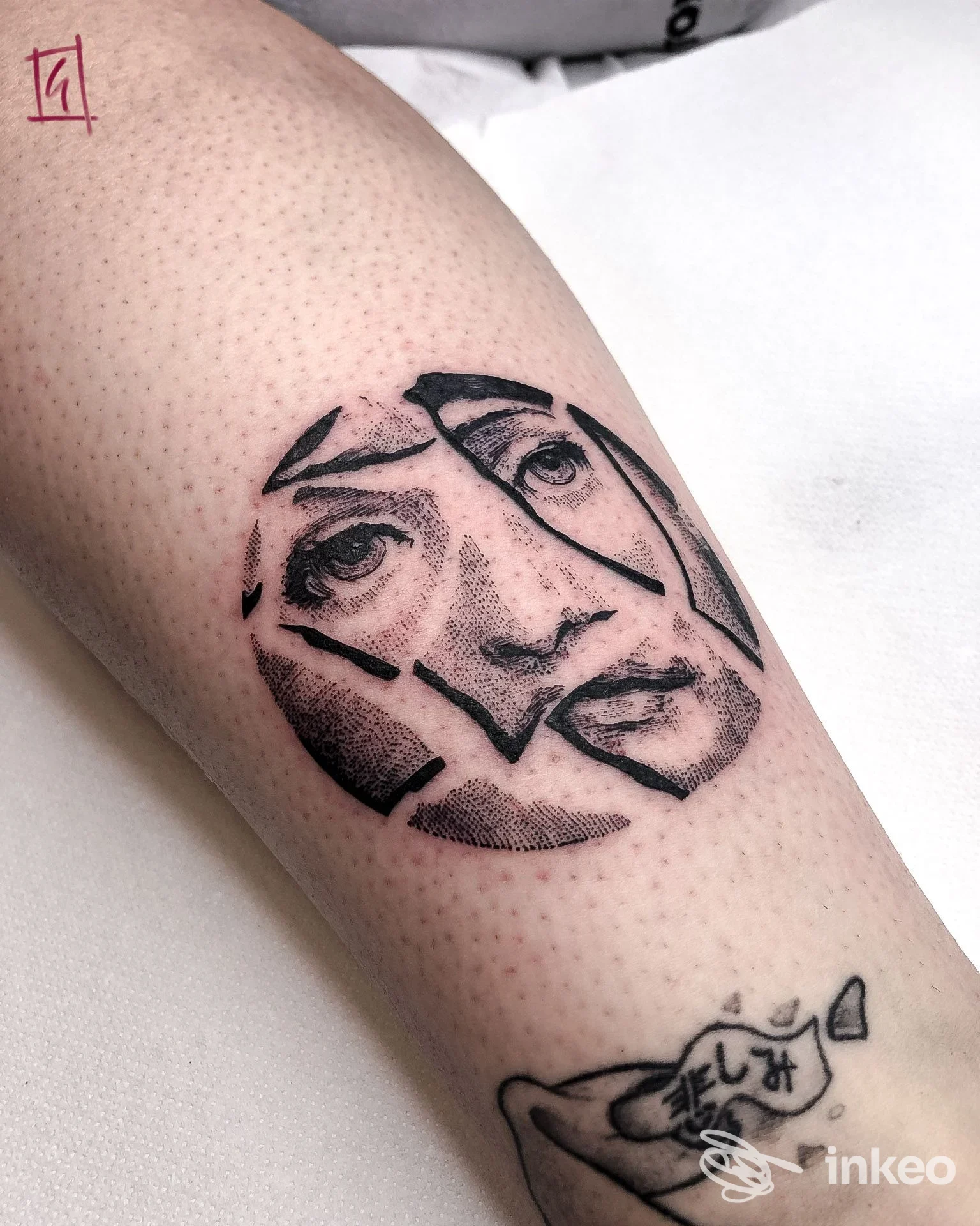 Tatuaggio a inchiostro nero a forma di volto frammentato sul polpaccio, realizzato da Giada Tattoo a San Martino di Lupari.