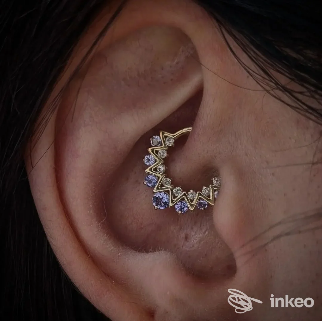 Primo piano di un piercing alla conca con gioiello in oro e pietre, foto fornita da GioRGia BodyPiercer a San Donà di Piave.