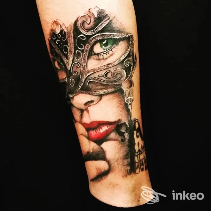 Tatuaggio realistico su avambraccio raffigurante un volto mascherato; Giovanna Zorn GioTattoo, Venezia.
