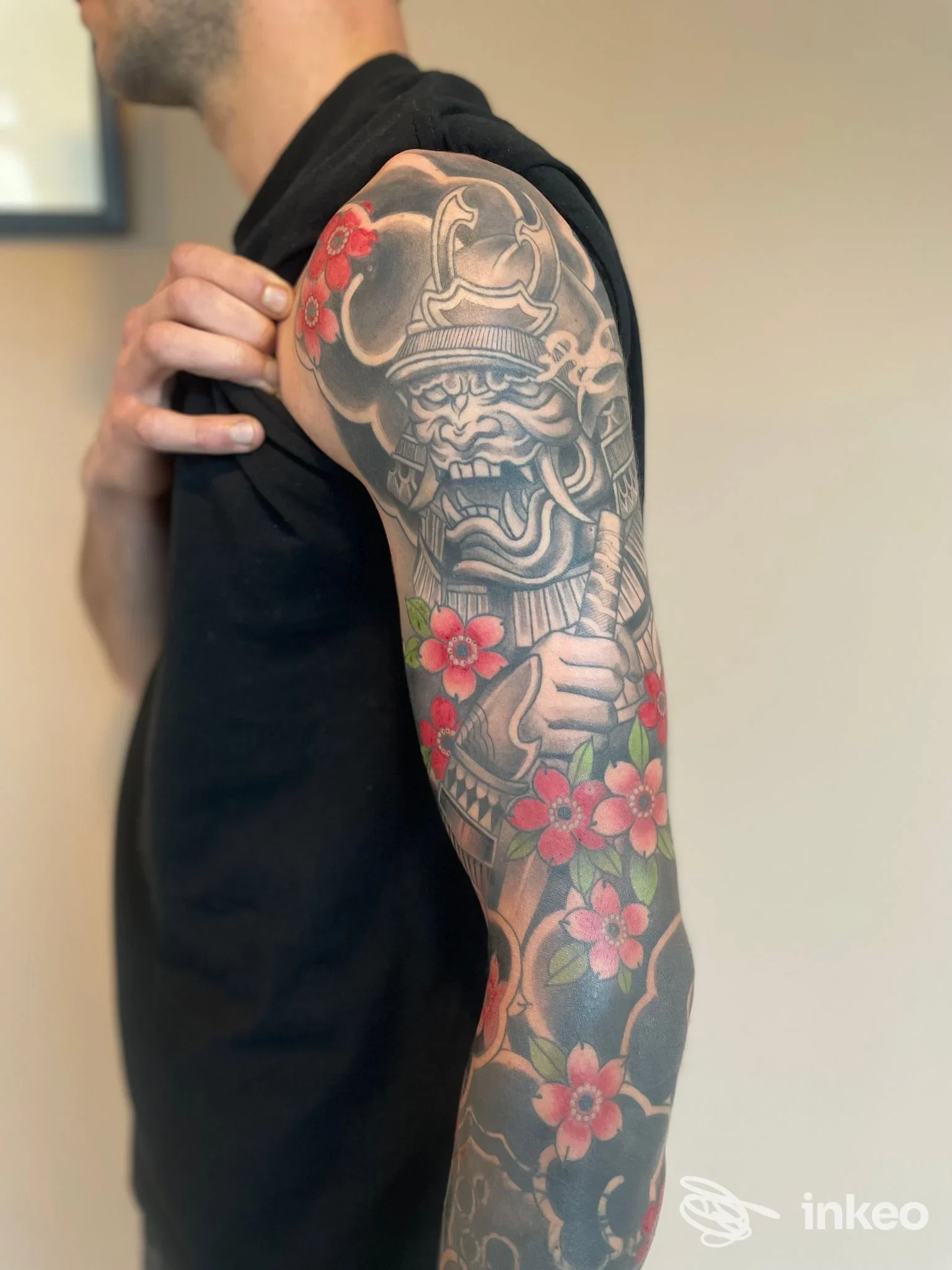 Tatuaggio full sleeve con motivo figurativo e fiori rossi sul braccio sinistro, HandMade Tattoo Lab, Este.