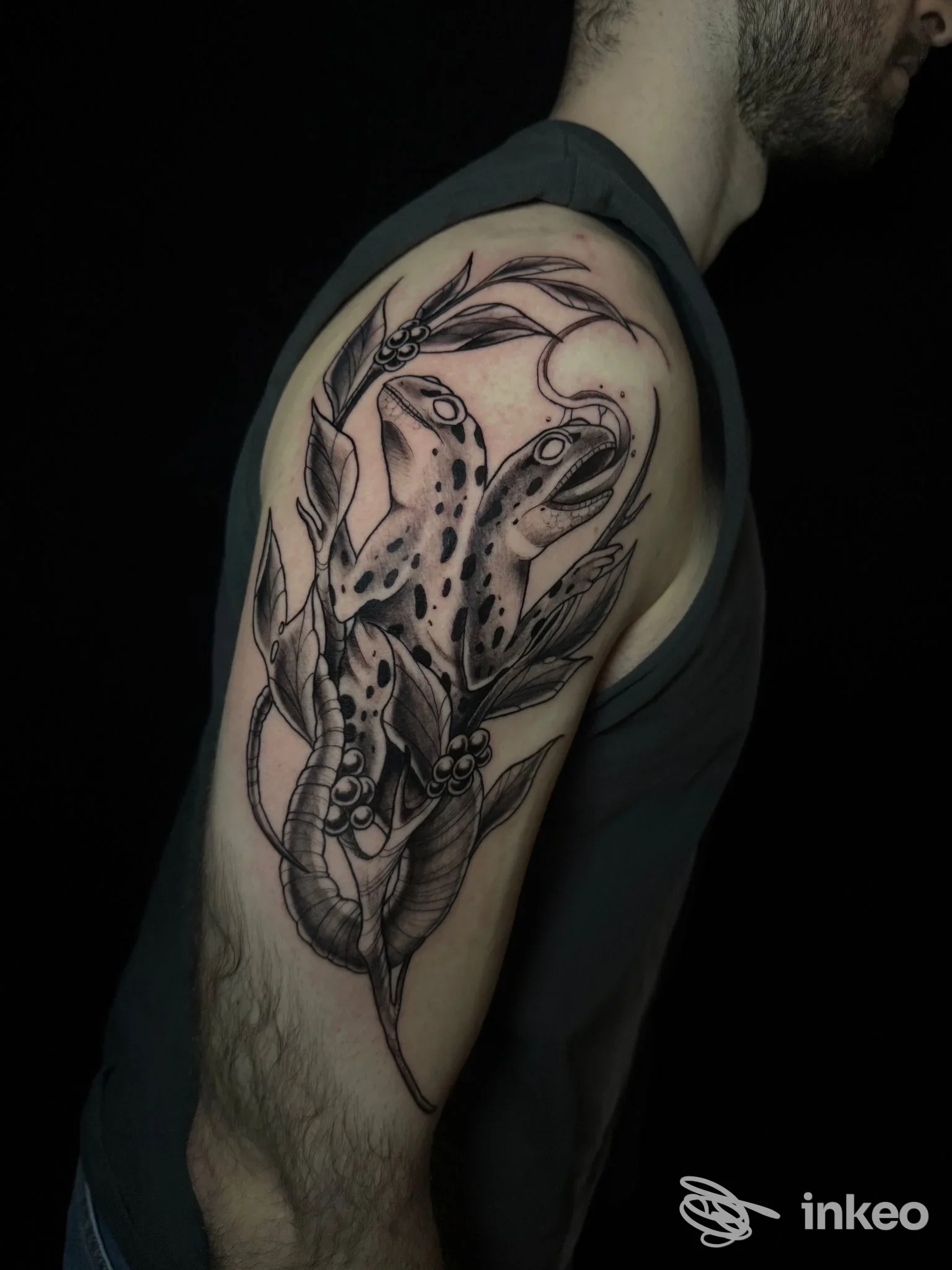 Tatuaggio sul braccio di un uomo realizzato da Dory Ink Tattoo: disegno a linee nere con elementi vegetali e creature intrecciate, sfondo nero.