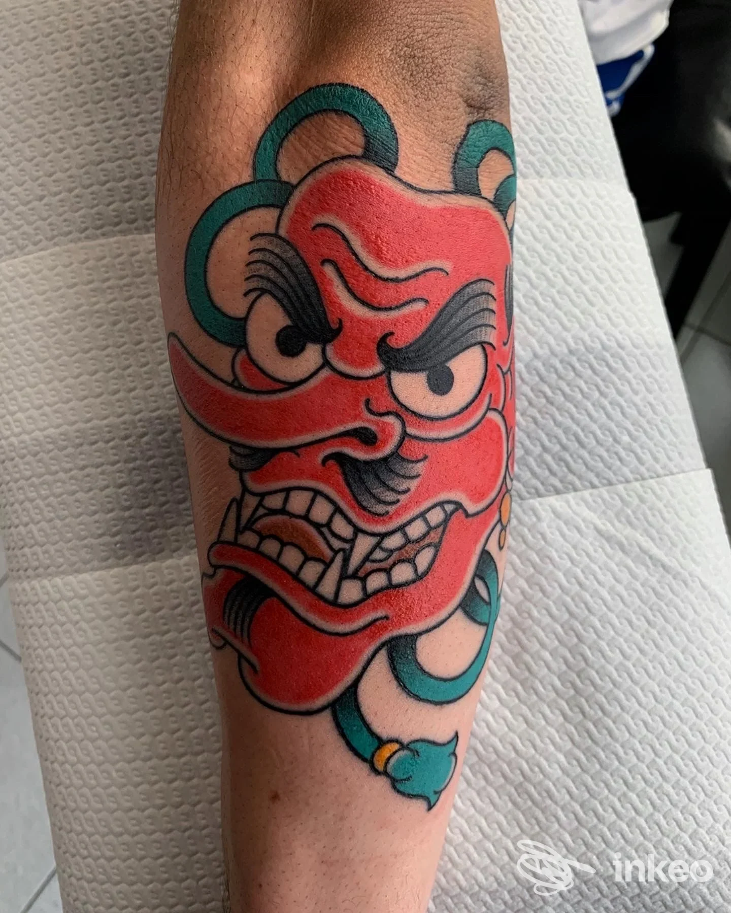 Tatuaggio su avambraccio raffigurante una maschera rossa, fotografato nello studio Hurt Me Babe Tattoo a Padova.