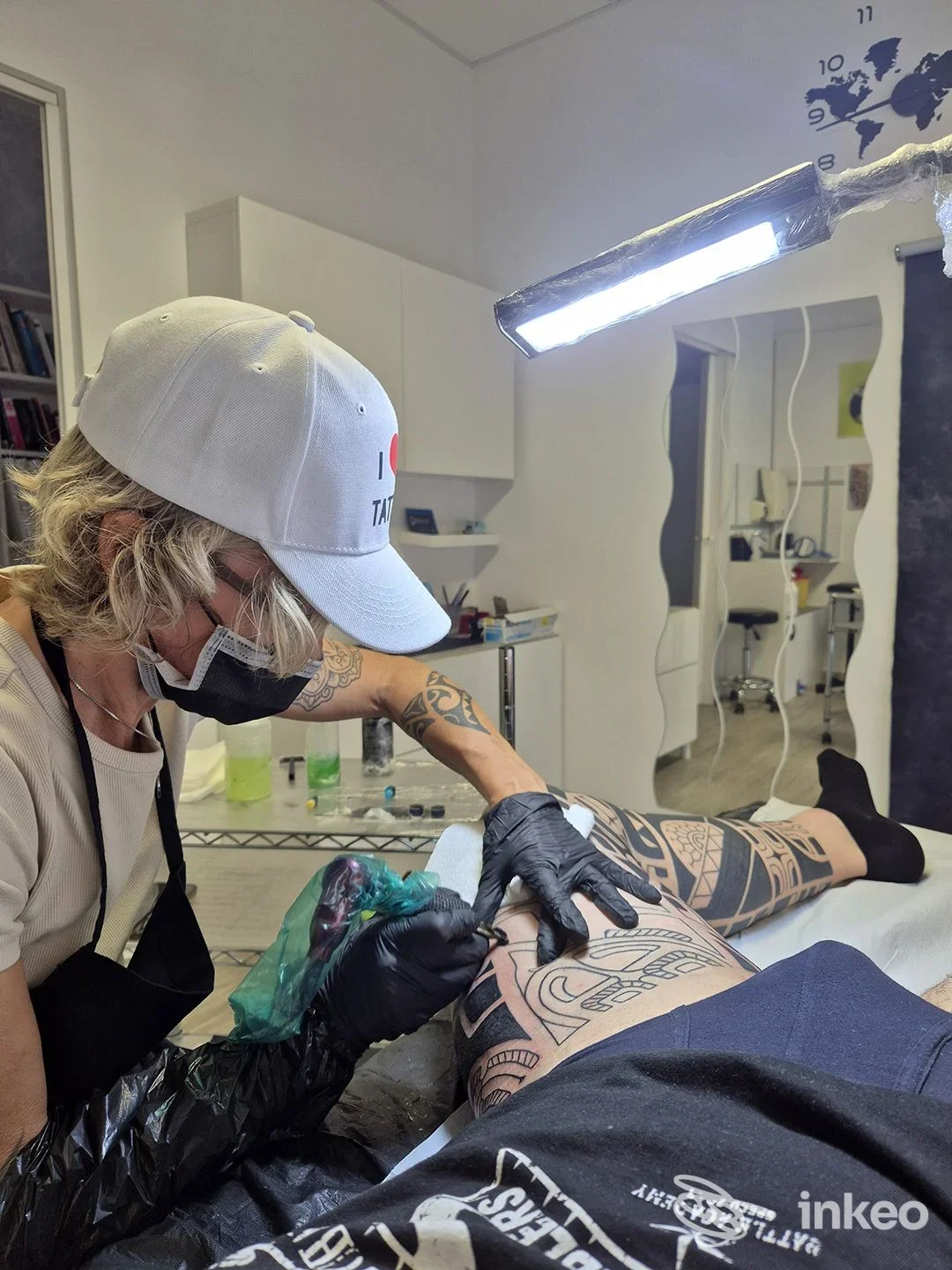 Artista mentre esegue un tatuaggio nero sul polpaccio di un cliente nello studio I LOVE TATTOO a Casalserugo.