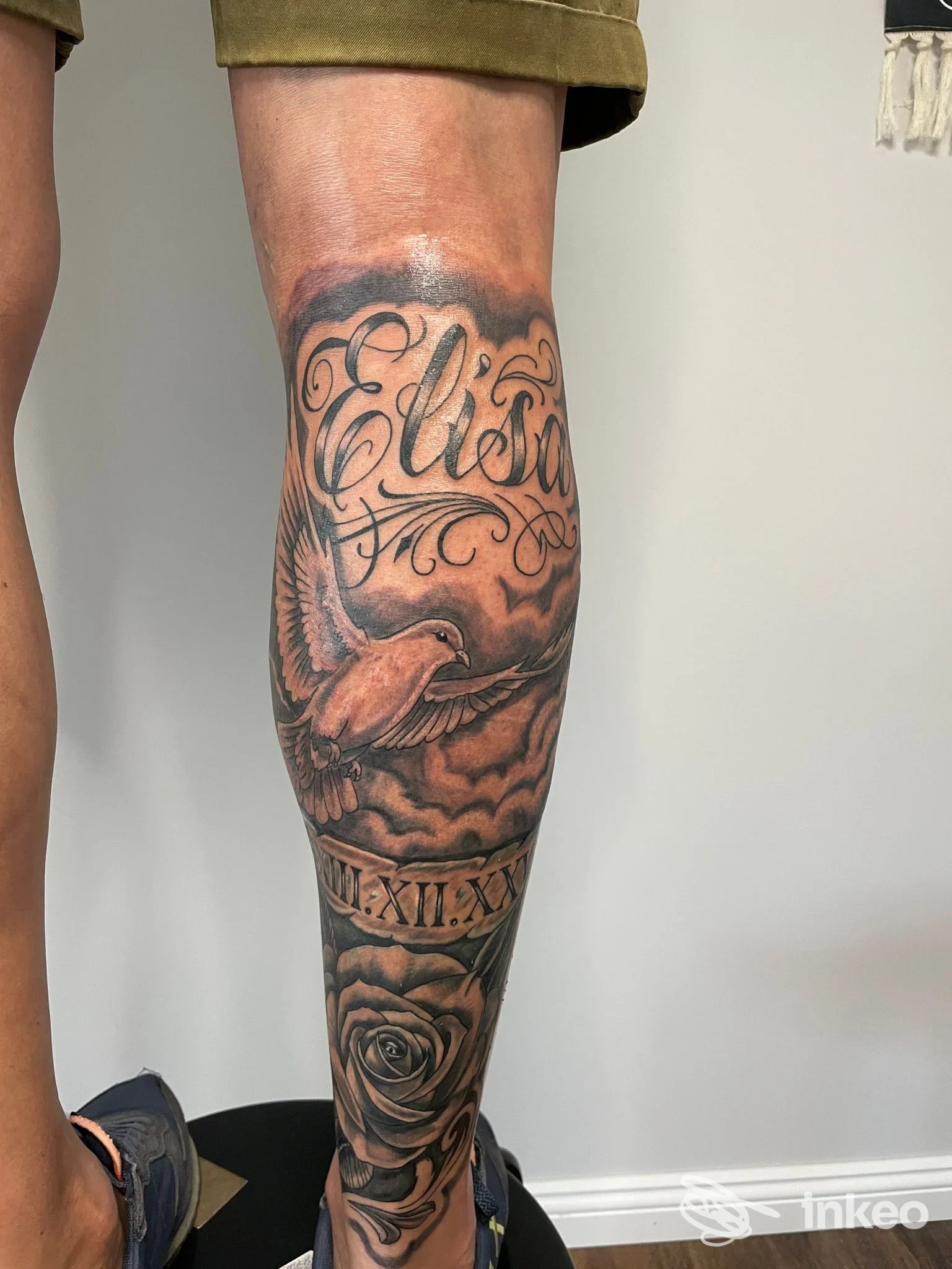Tatuaggio black & grey su polpaccio con lettering, colomba e rosa, foto fornita da Hypothetical Tattoo Lab, Martellago.