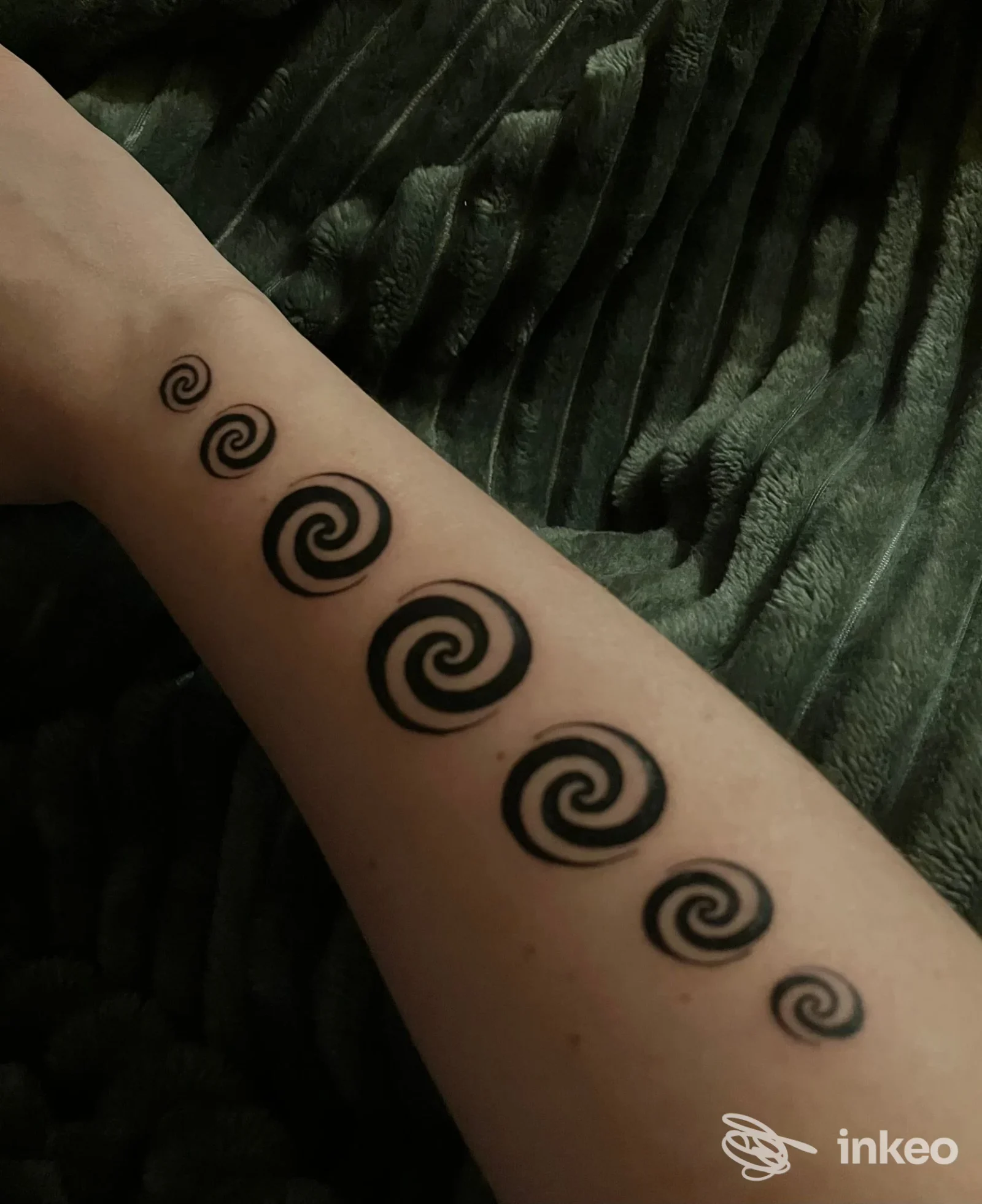 Avambraccio tatuato con una serie di spirali nere, John Doe Tattoo Vigonza.