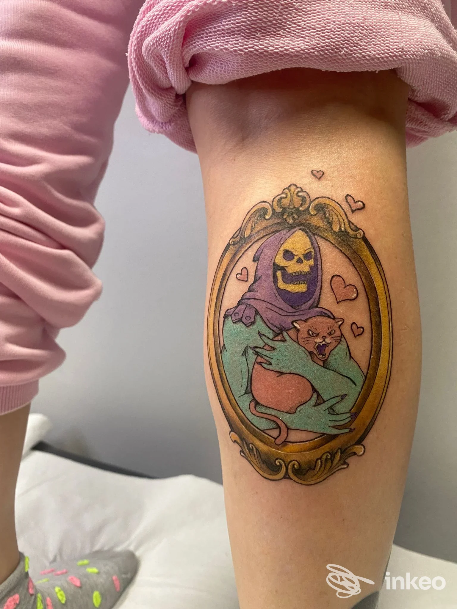 Tatuaggio colorato sul polpaccio con una figura scheletrica che abbraccia un gatto - L’Inchiostreria Tattoo Studio, Monselice.