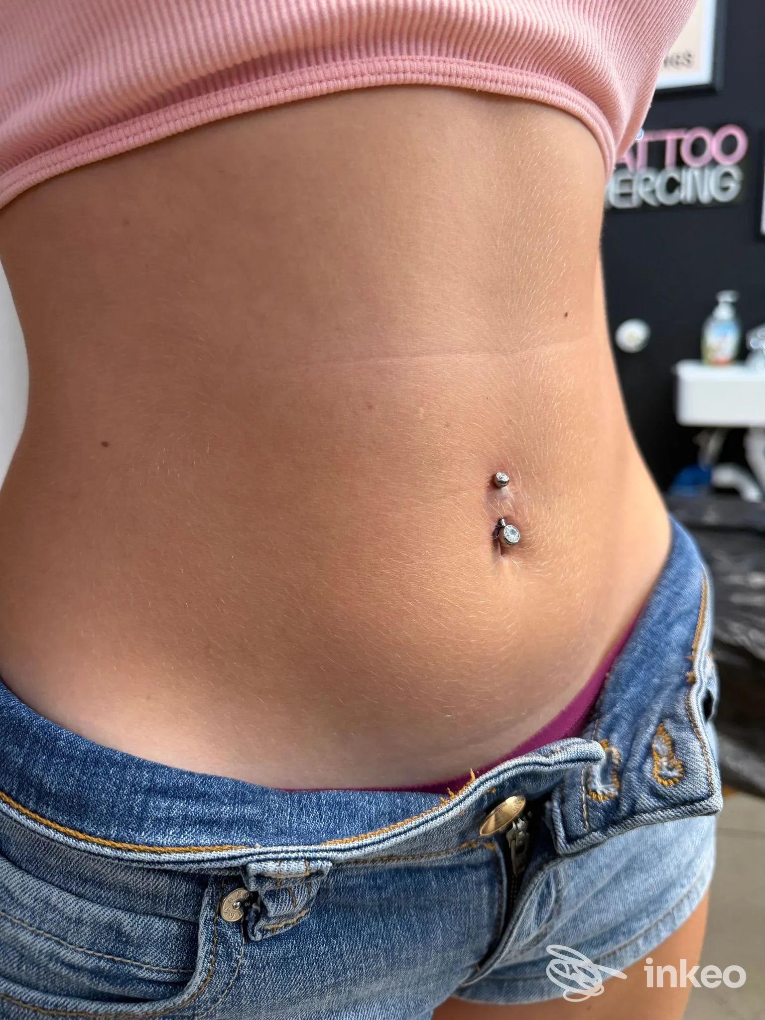 Primo piano di un piercing ombelicale su addome, foto dallo studio Ink Drop Tattoo Studio a Quarto d'Altino.