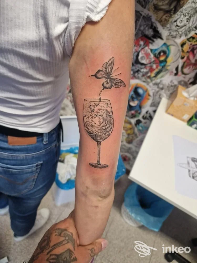 Tatuaggio sull'avambraccio raffigurante un calice con onde e una farfalla, realizzato presso KillCandy Tattoo & Piercing Studio, Volpago del Montello.
