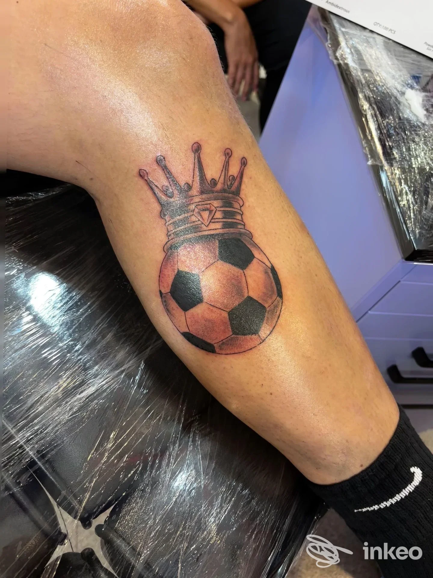 Tatuaggio su polpaccio: pallone da calcio con corona, linee nette e ombreggiature. Foto scattata nello studio KillCandy Tattoo & Piercing Studio, Volpago del Montello.