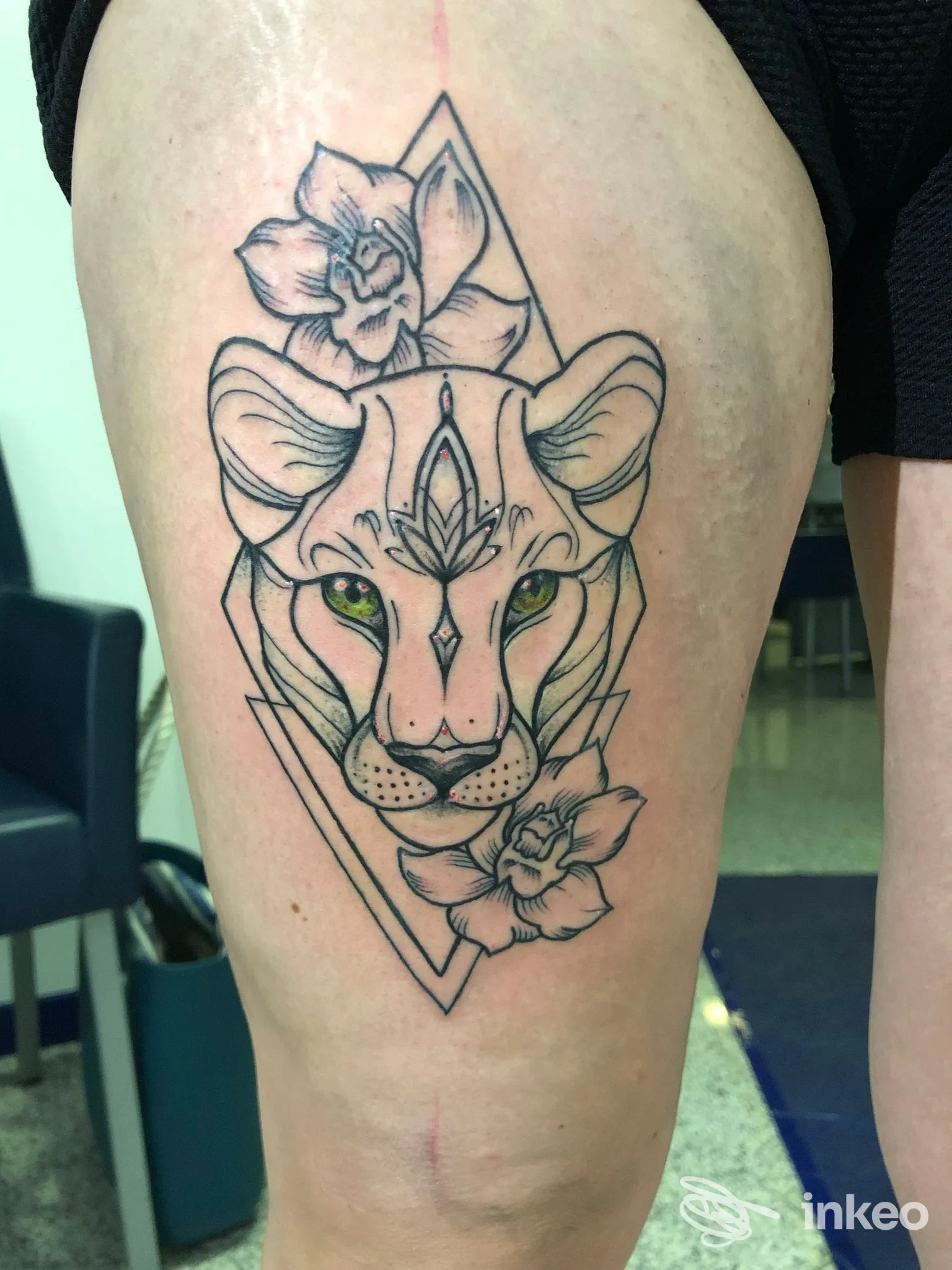 Tatuaggio linework di testa di felino con fiori sulla coscia, eseguito da La Belva tattoo e piercing a Zermeghedo.