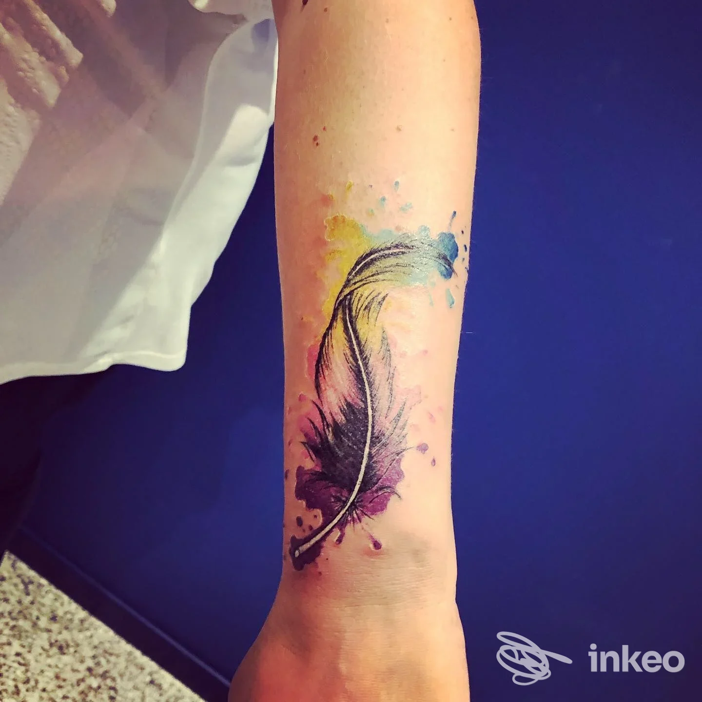 Tatuaggio a forma di piuma con effetto acquerello sull'avambraccio, La Belva tattoo e piercing, Zermeghedo.