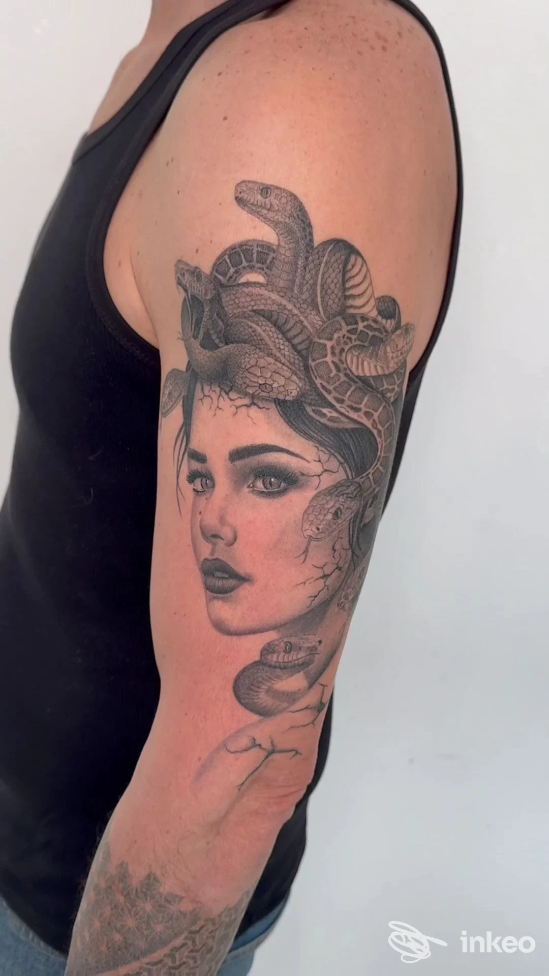 Tatuaggio black & grey di volto femminile avvolto da serpenti sul braccio superiore. Magd’Art Tattoo & Piercing, Castelfranco Veneto.