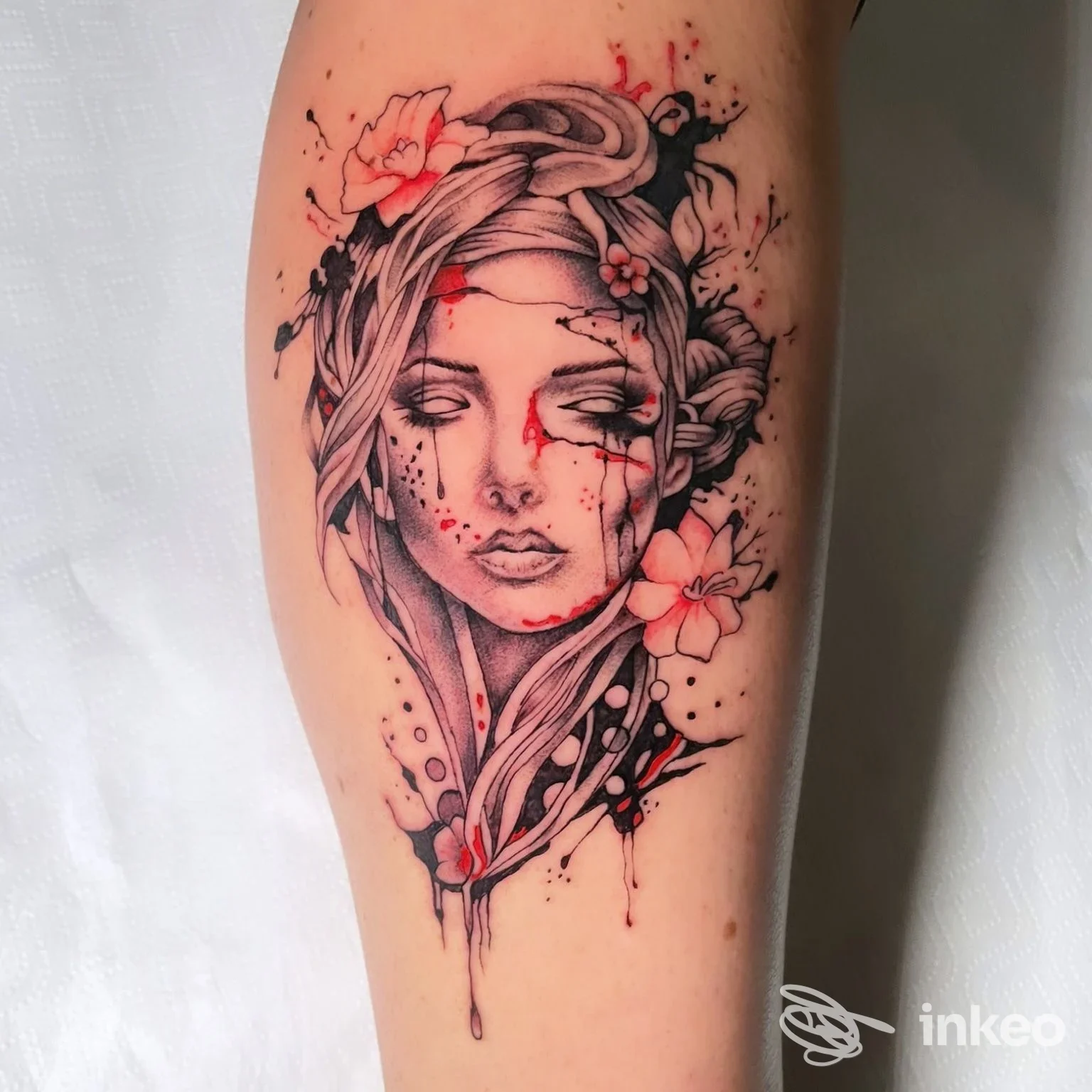 Tatuaggio stilizzato di volto femminile con fiori e schizzi rossi su avambraccio, Mamma Non Vuole Tattoo Ink, Monteforte d'Alpone.