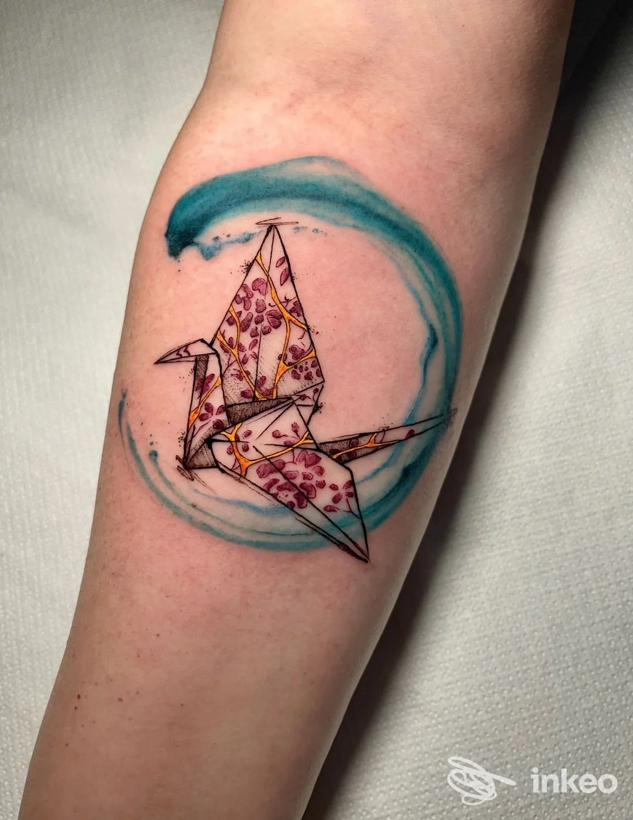 Tatuaggio di gru origami con motivi floreali e sfumatura acquerello turchese, Not Equal Tattoo (Veleno Tattoo), Thiene.
