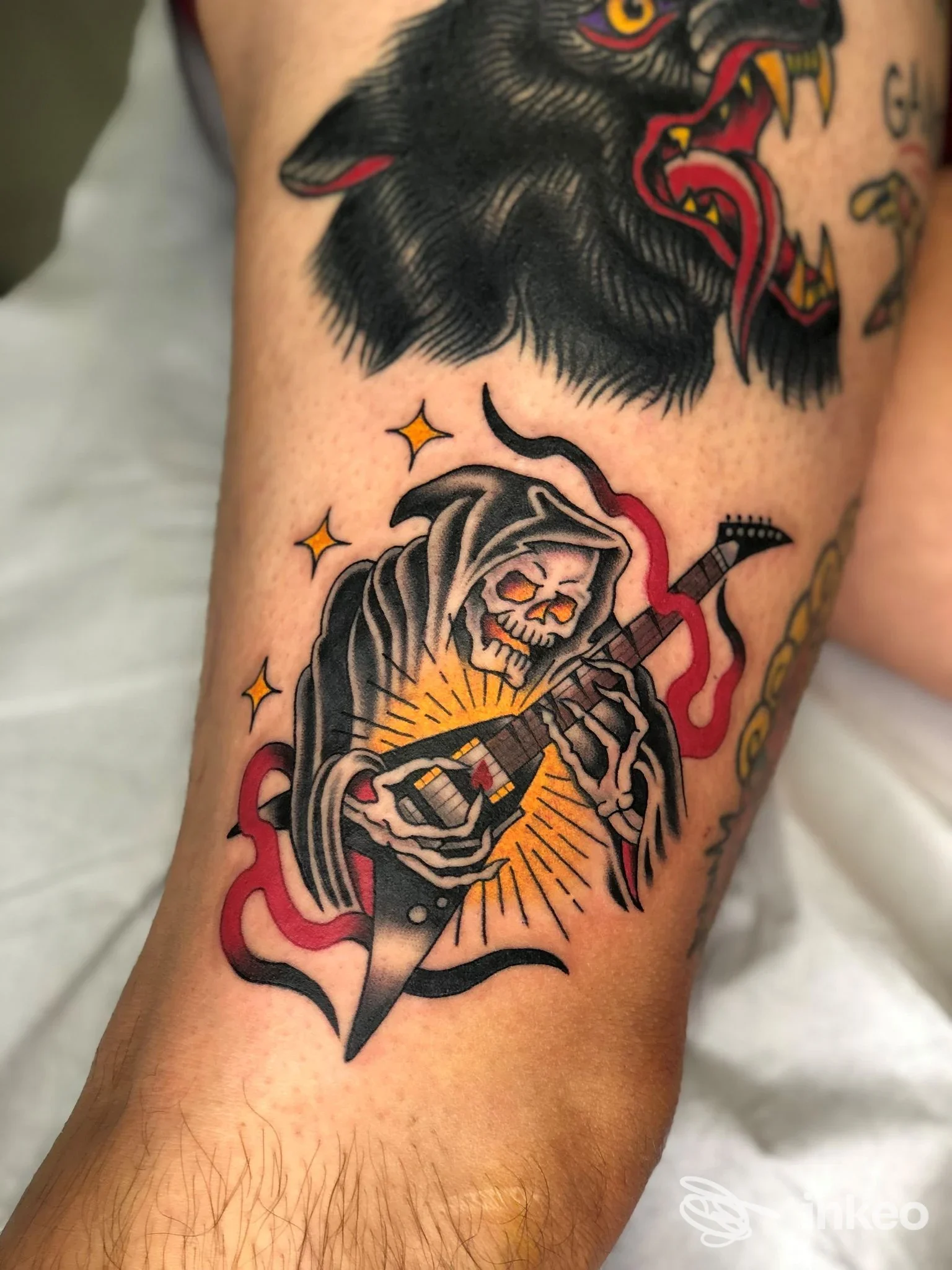 Tatuaggio in stile tradizionale di uno scheletro con chitarra sull'area inferiore della gamba, realizzato da Mantra Tattoo Studio, Este.