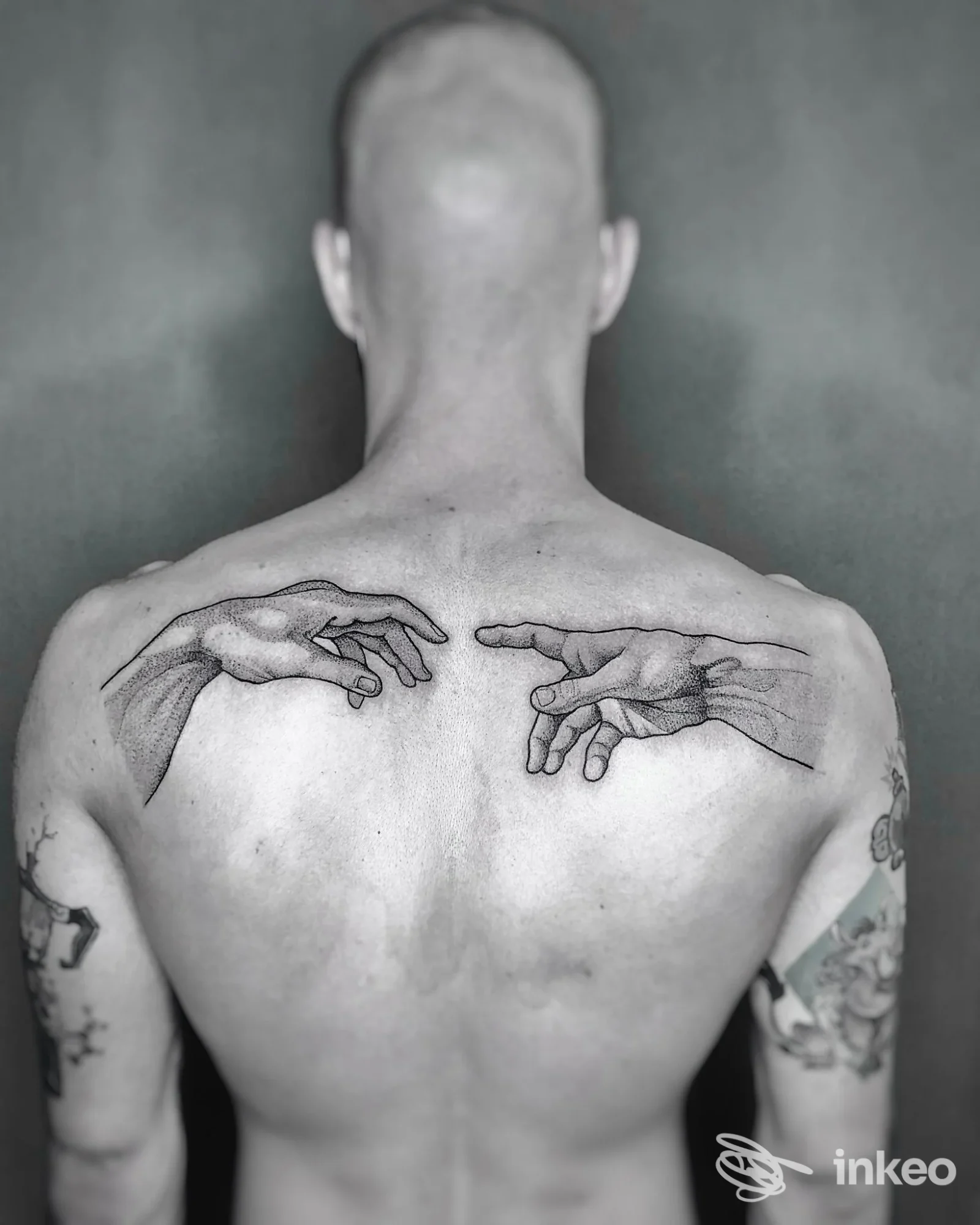 Due mani tatuate in stile linework sulla parte superiore della schiena, foto fornita da Mirabilia Tattoo Studio a Treviso.