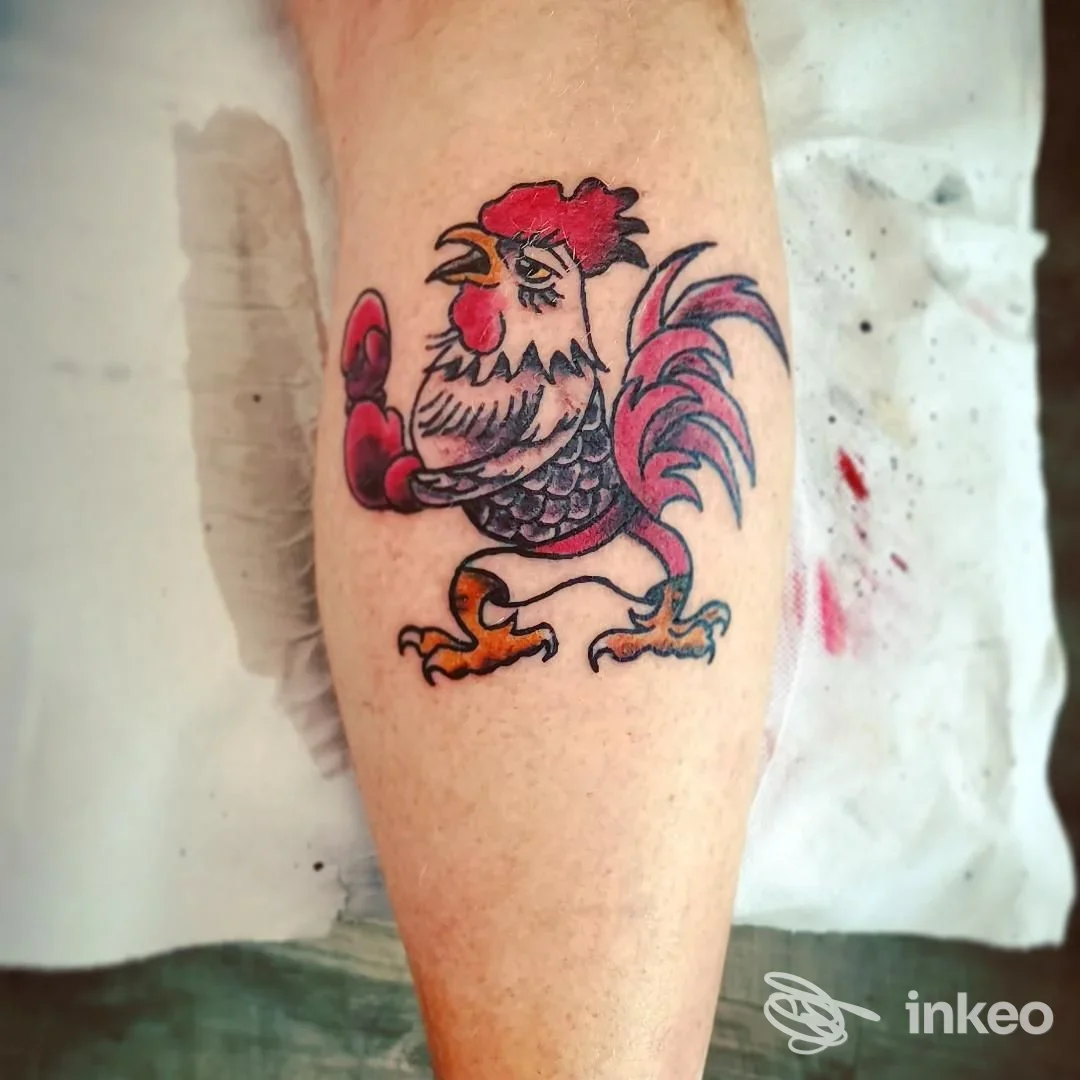 Tatuaggio di un gallo colorato sul polpaccio, fotografato allo studio Old Skull Tattoo di Diliso Elia Raffaello, Verona.