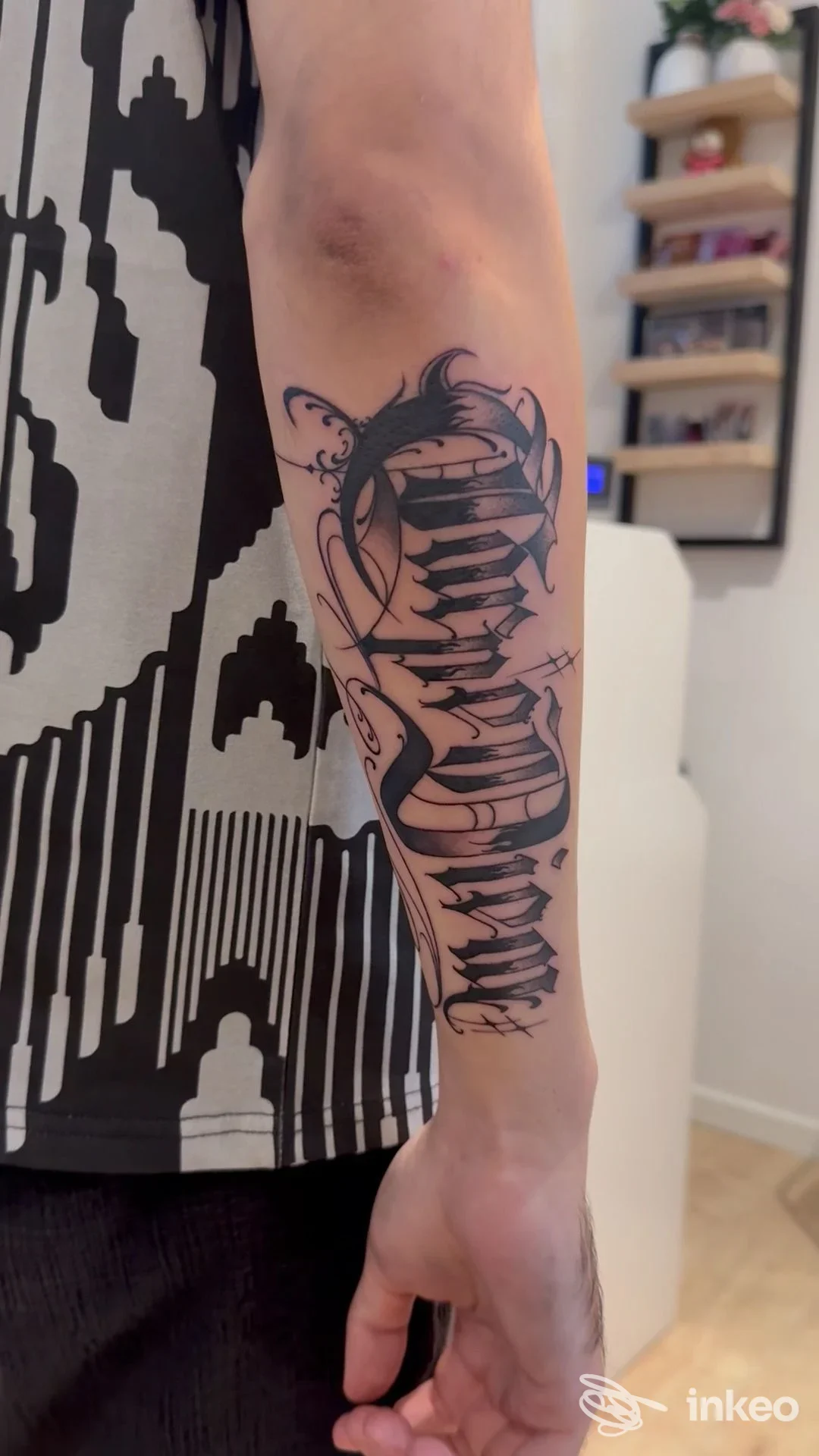 Tatuaggio script nero sull'avambraccio sinistro fotografato in interno, immagine fornita da One Studio Tattoo & Piercing, Venezia.