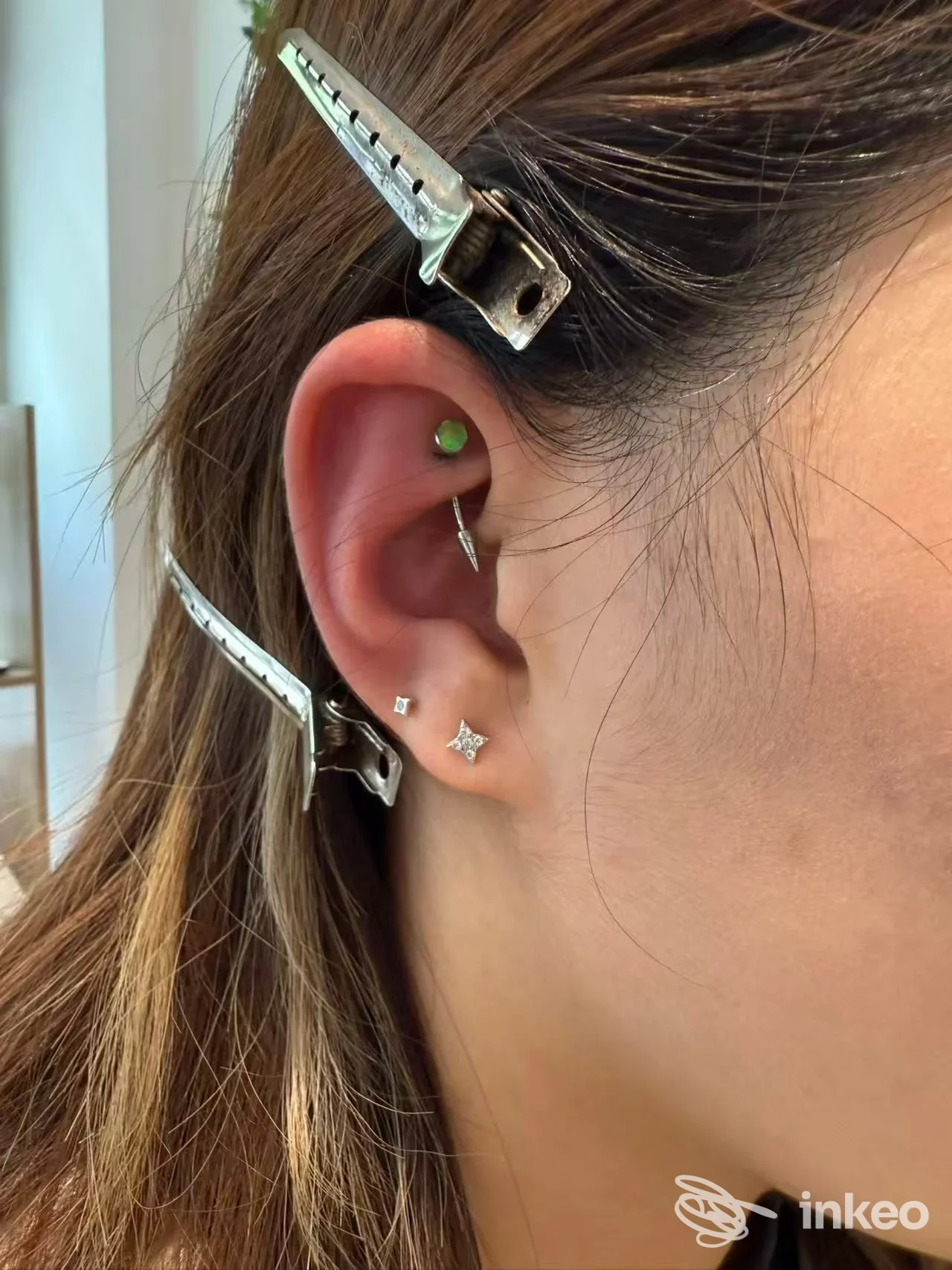 Primo piano dell'orecchio con tre piercing; immagine fornita da One Studio Tattoo & Piercing, Venezia.