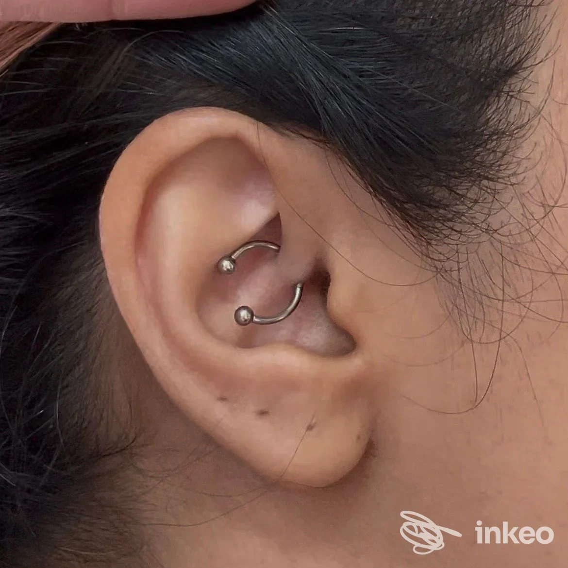 Primo piano di un orecchio con due piercing a cerchio, foto di One Studio Tattoo & Piercing, Venezia.