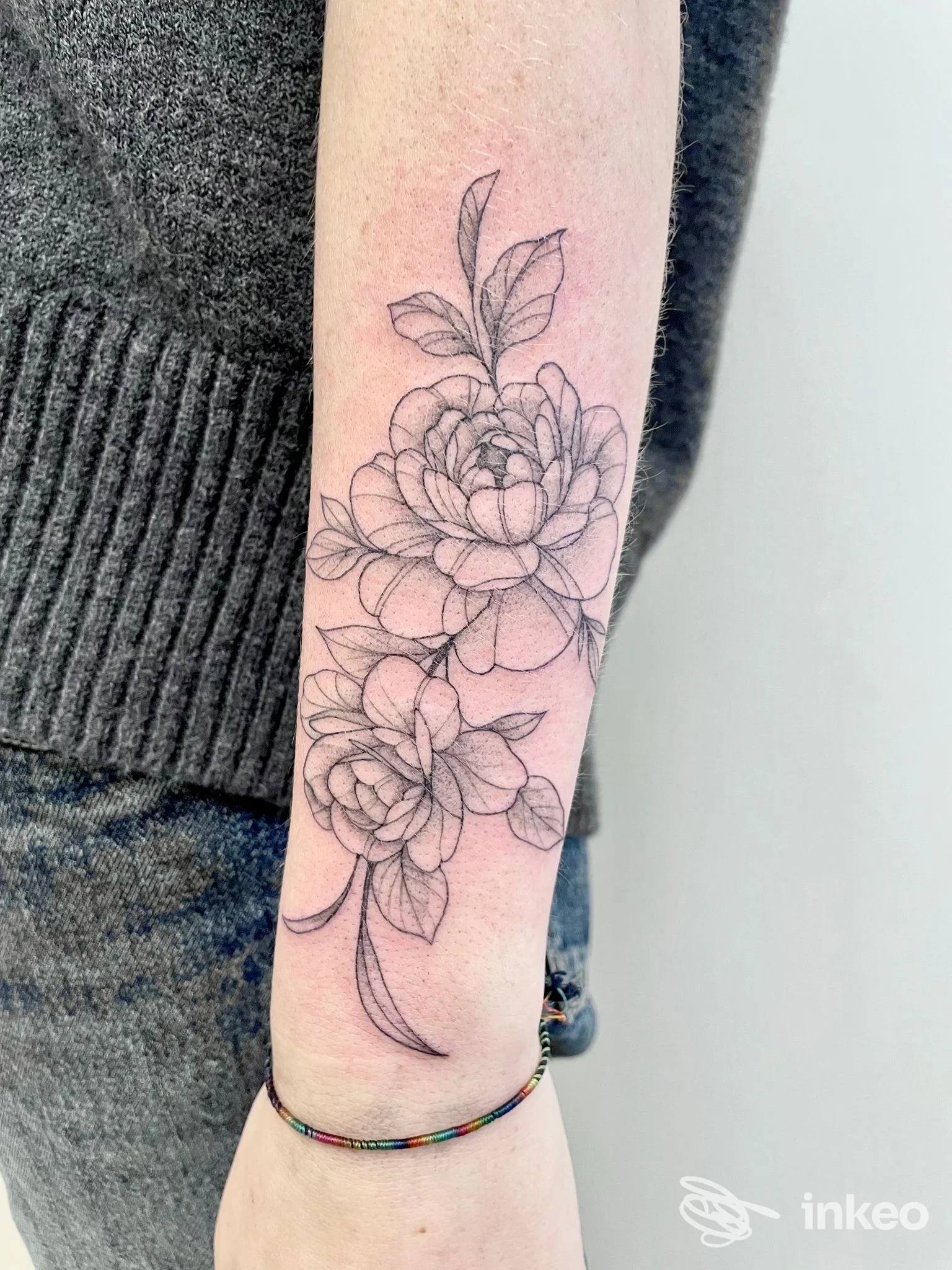 Tatuaggio floreale a linee sottili sull'avambraccio interno, lavoro di PELLE D’OCA tattoo studio a Breganze.