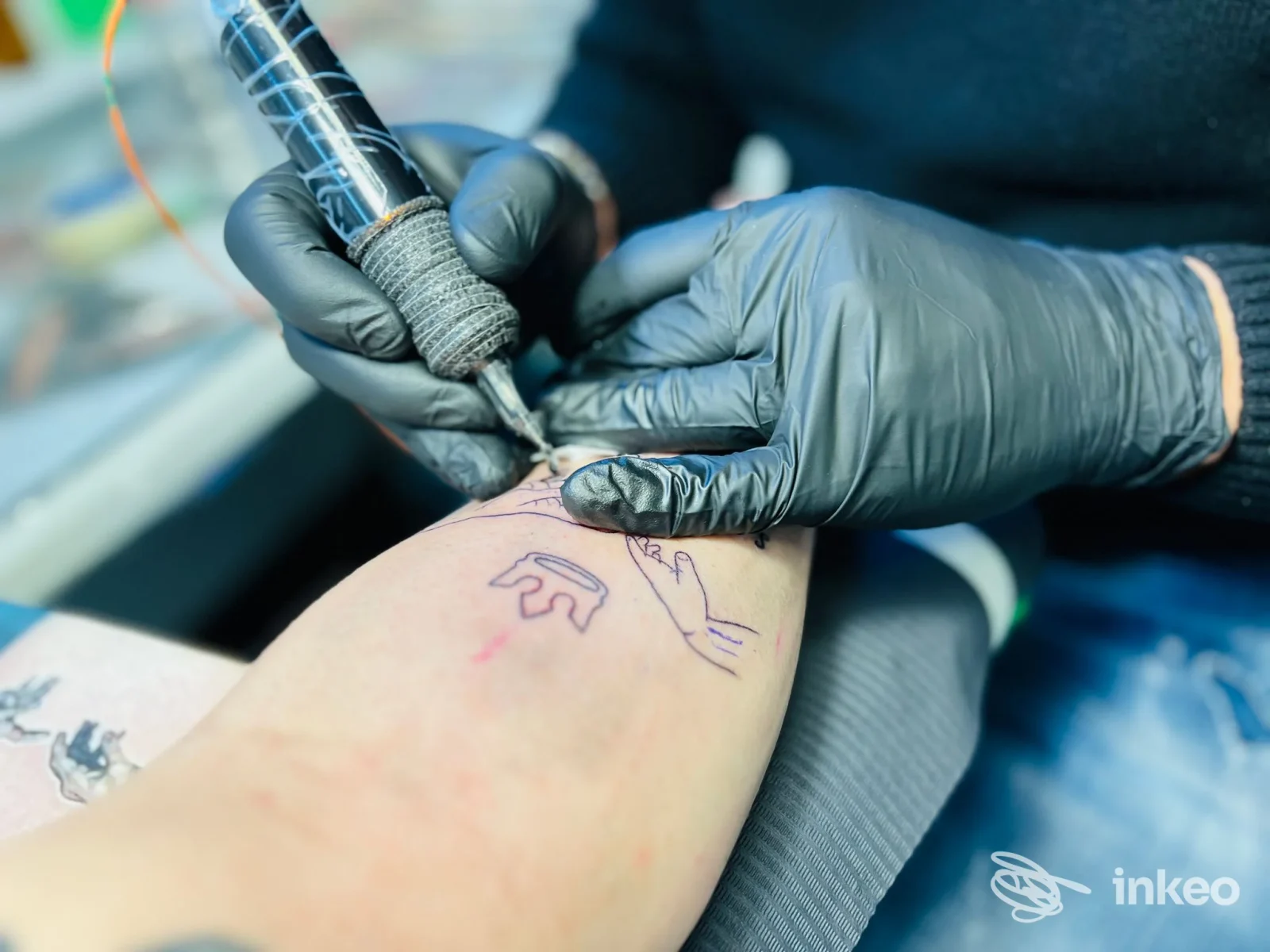 Tatuaggio in corso sull'avambraccio eseguito da PROJECT M-TATTOO, Casaleone, con il tatuatore che lavora indossando guanti neri.