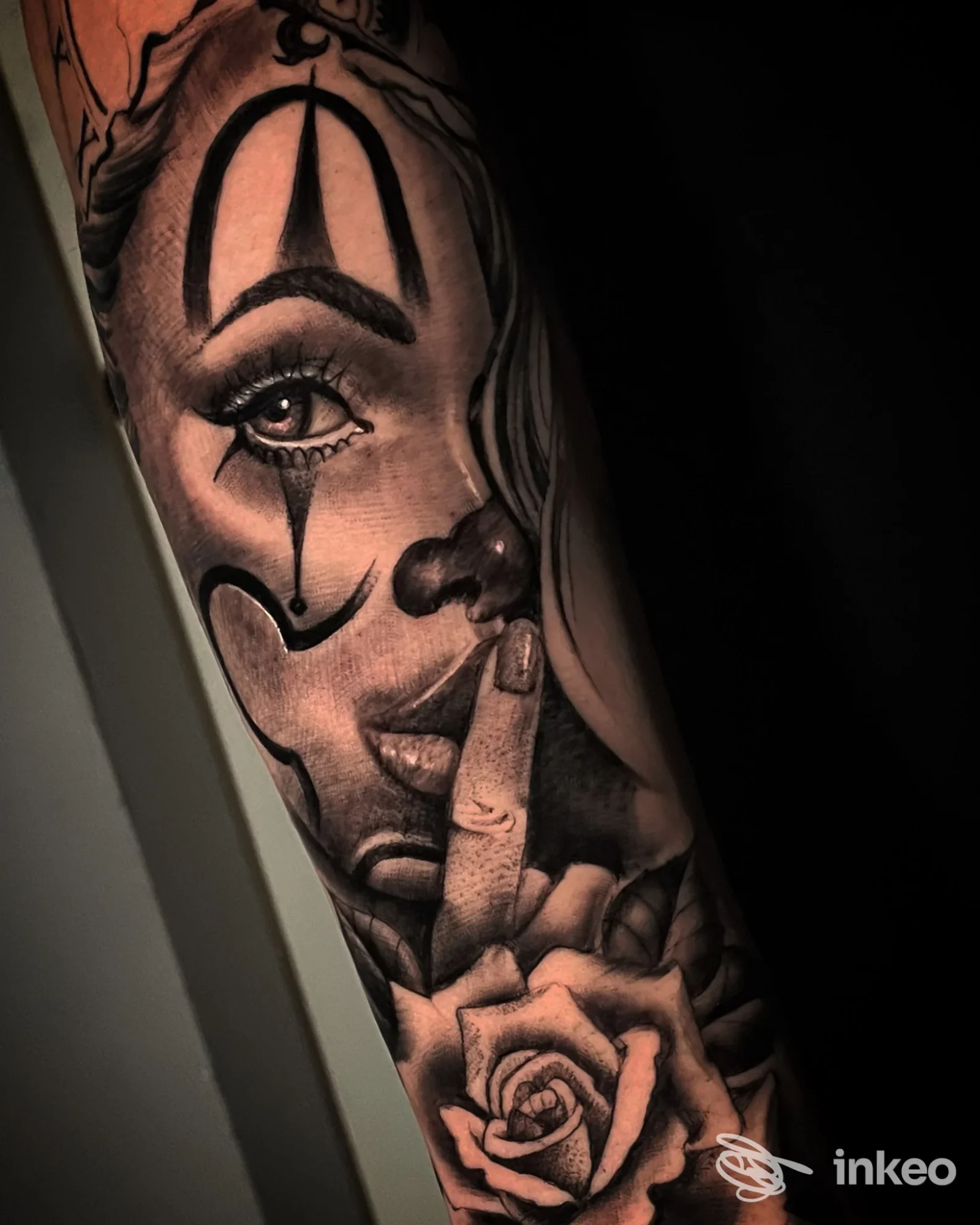 Ampio tatuaggio in bianco e nero su avambraccio con volto di donna in stile clown e rosa, Original Sin Tattoo Shop, Nogara.