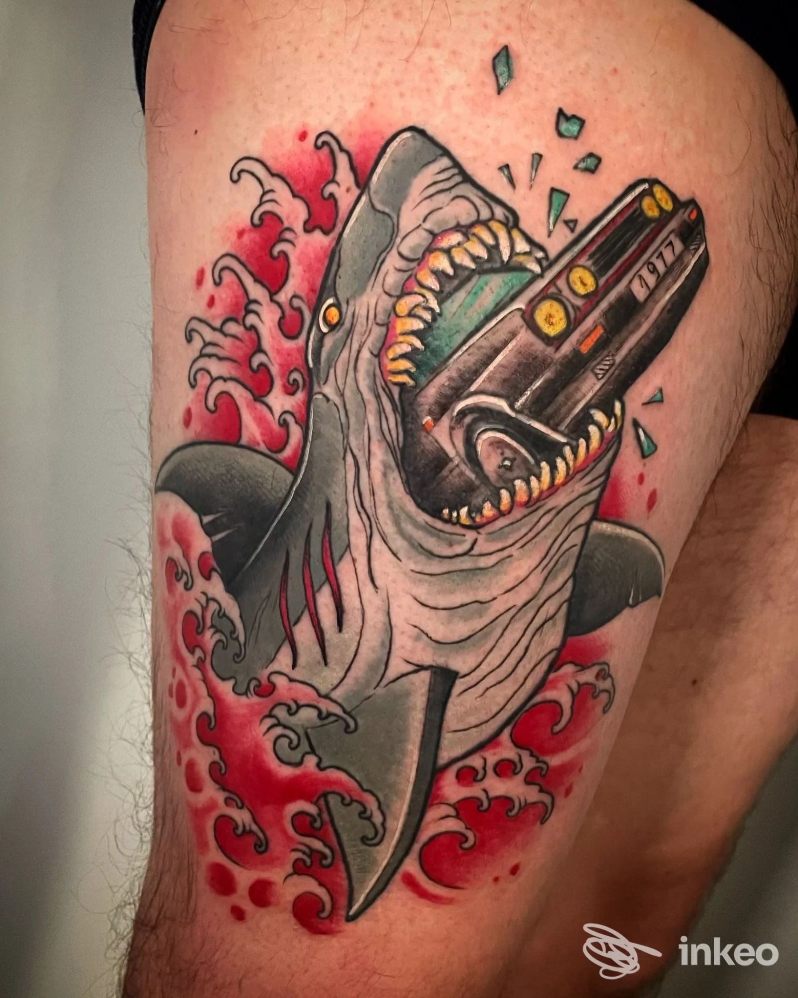 Tatuaggio su coscia: squalo che morde un'auto, lavoro realizzato da Original Sin Tattoo Shop a Nogara.