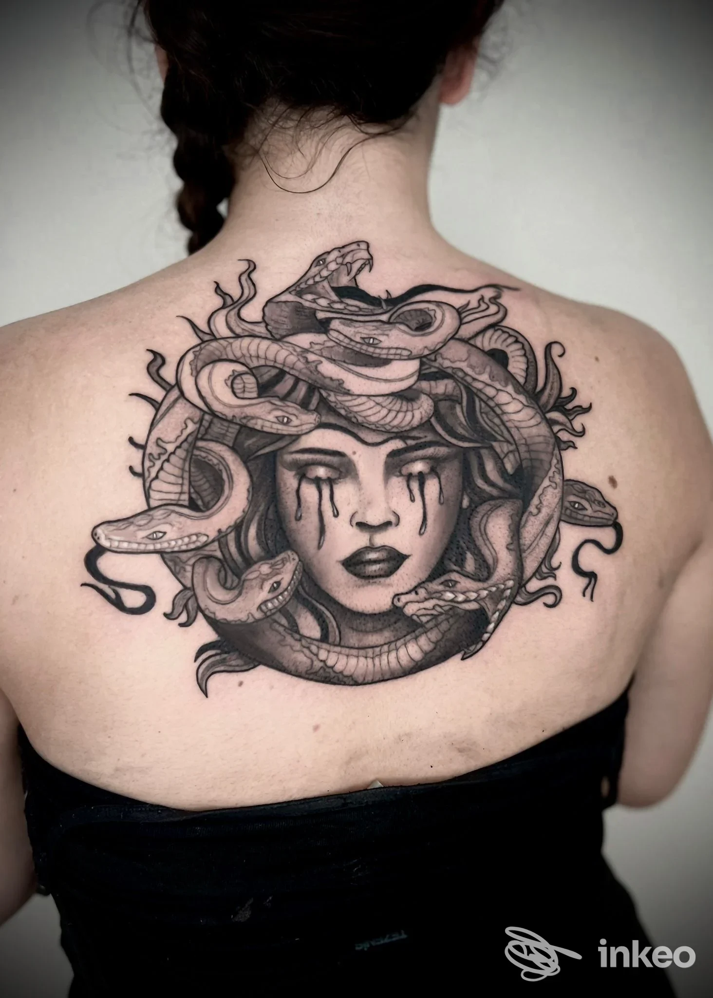 Grande tatuaggio in bianco e nero a tema Medusa sulla parte superiore della schiena, realizzato da Positive Studio Tattoo a Rubano.