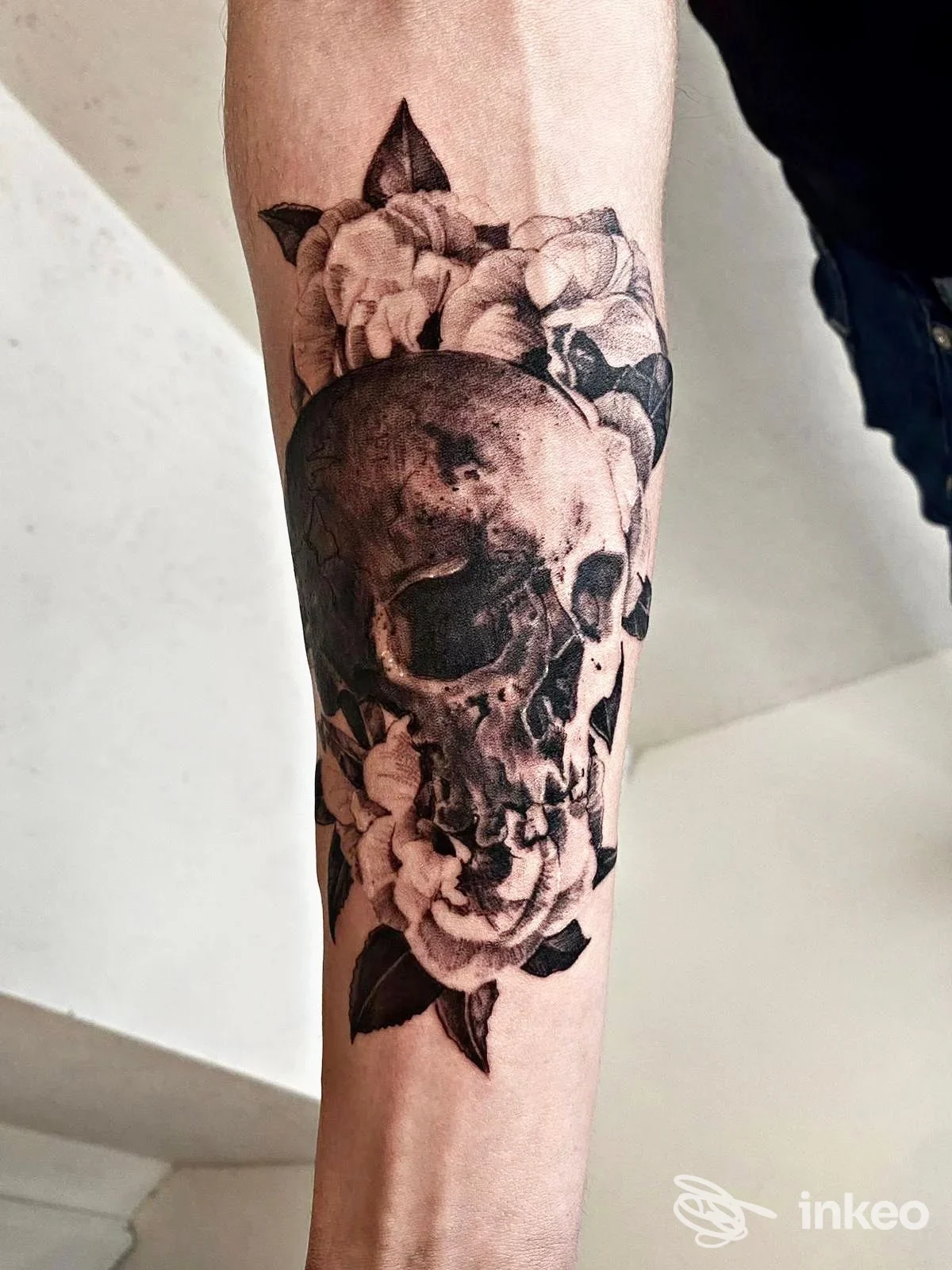 Tatuaggio realistico in bianco e nero di un teschio e fiori sull'avambraccio, Progressive Ink Tattoo, Dueville.