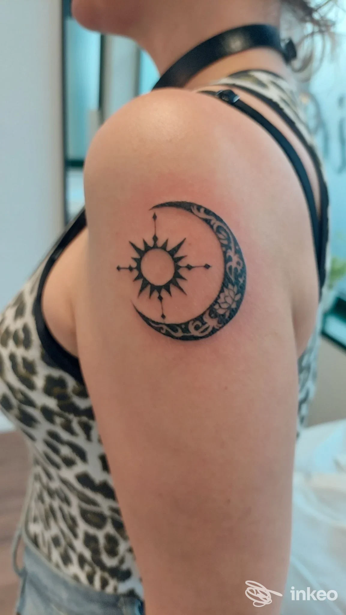 Tatuaggio a mezzaluna decorata e sole stilizzato sulla spalla di una persona, Purosangue Tattoo Studio, Terrossa.