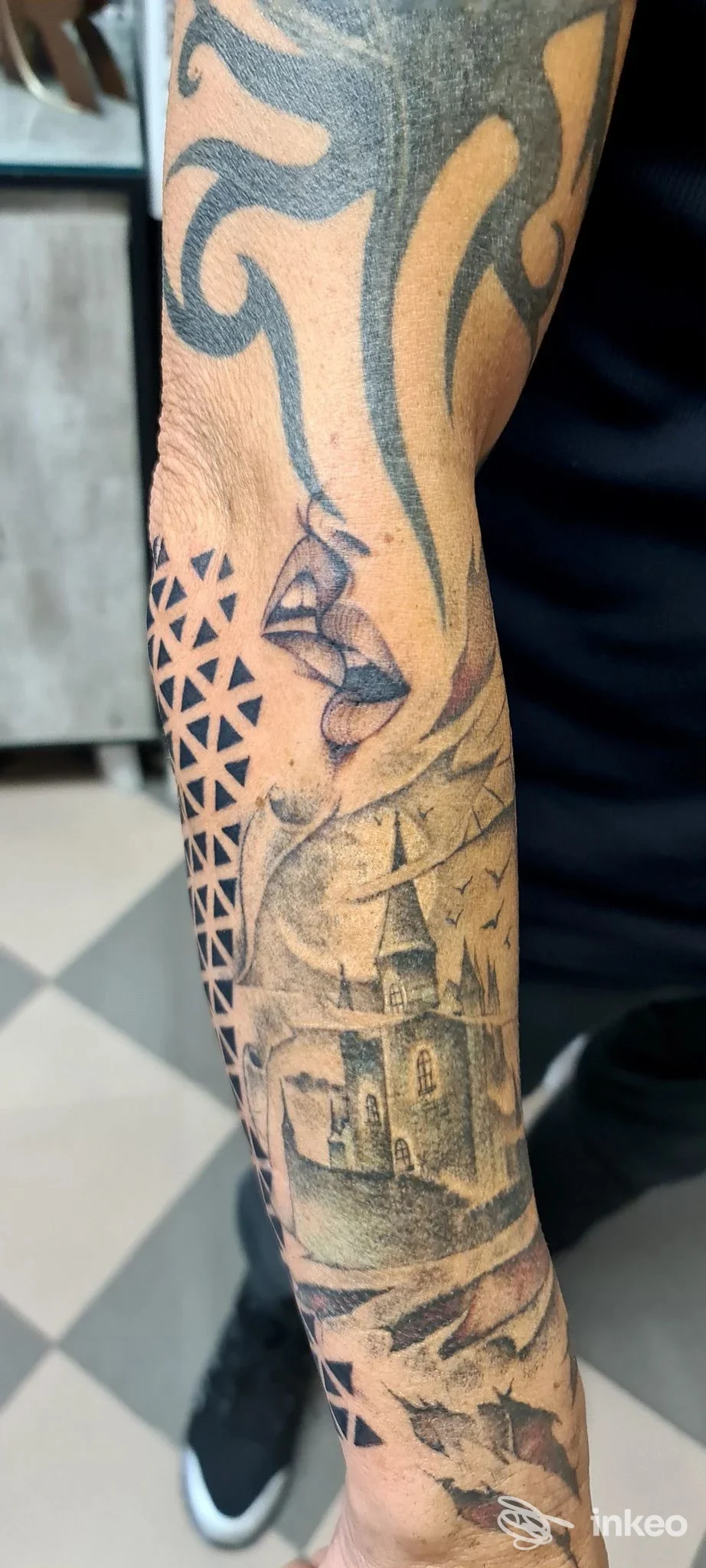 Avambraccio tatuato con motivi geometrici e scena di castello in bianco e nero, foto fornita da Rac Rac Tattoo Boutique - Legnago.